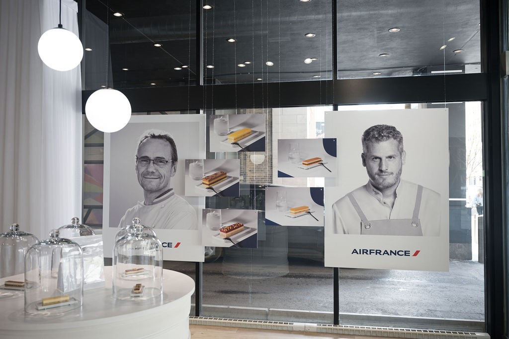 Window display featuring black-and-white portraits of chefs Laurent Le Daniel and Yann Couvreur with pastry imagery