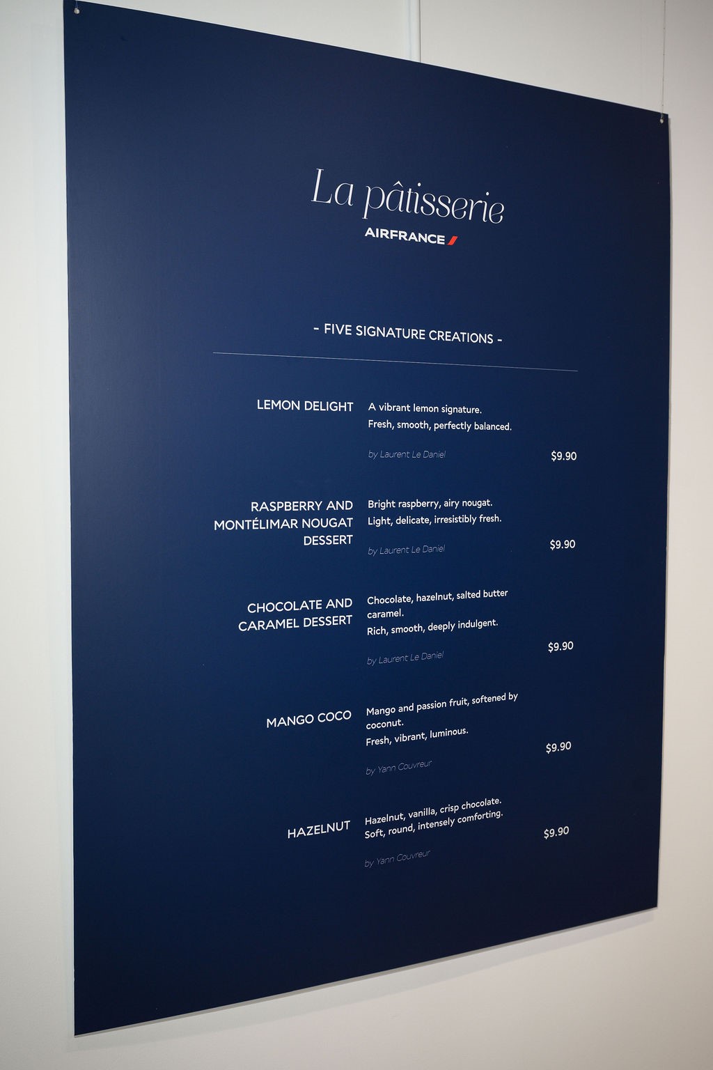 The pop-up menu board listing five pastries at $9.90 each