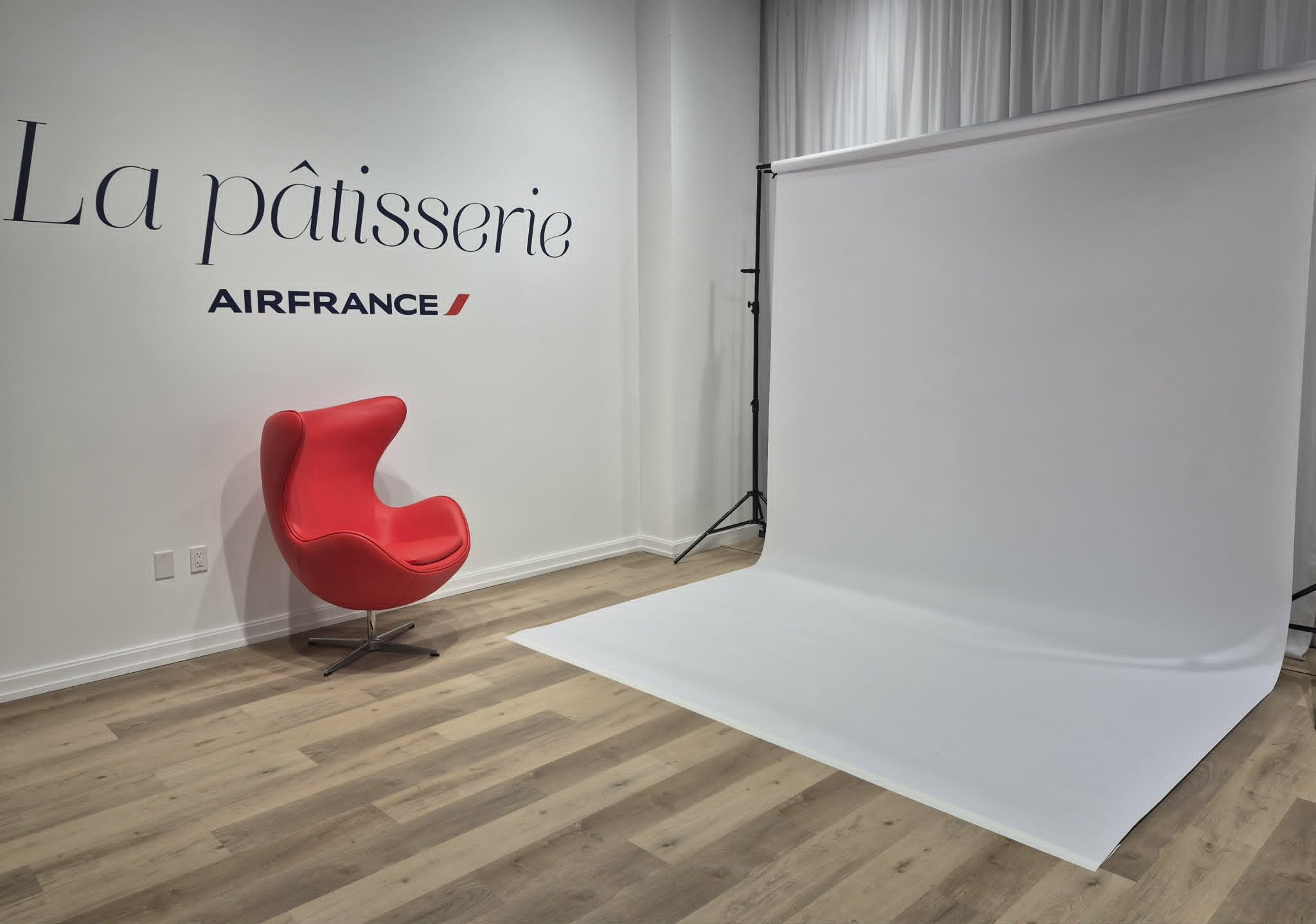 The Creators Studio at La pâtisserie with a red Egg chair and white photography backdrop