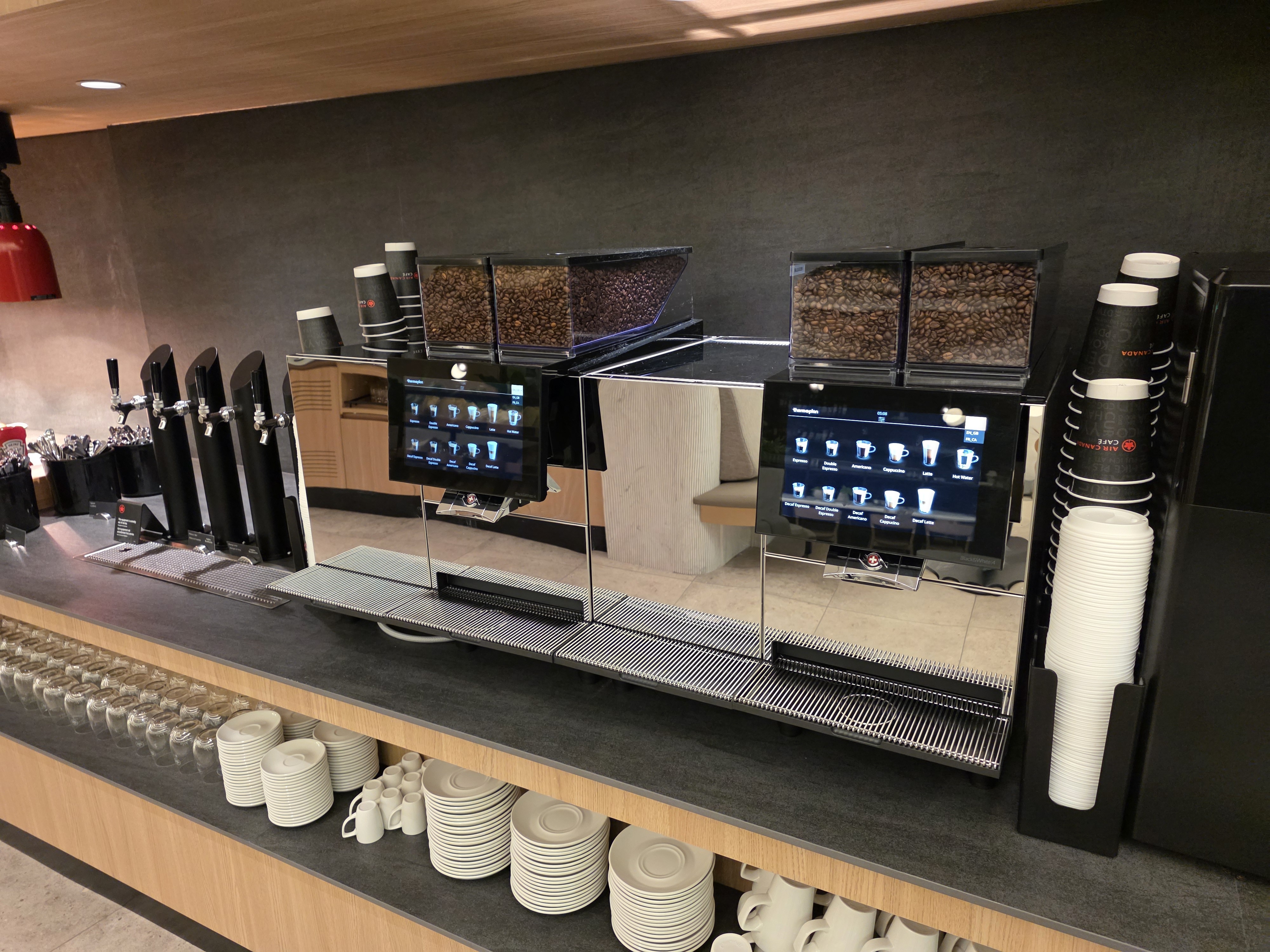 Two automated espresso machines with bean hoppers at the Air Canada Café YVR