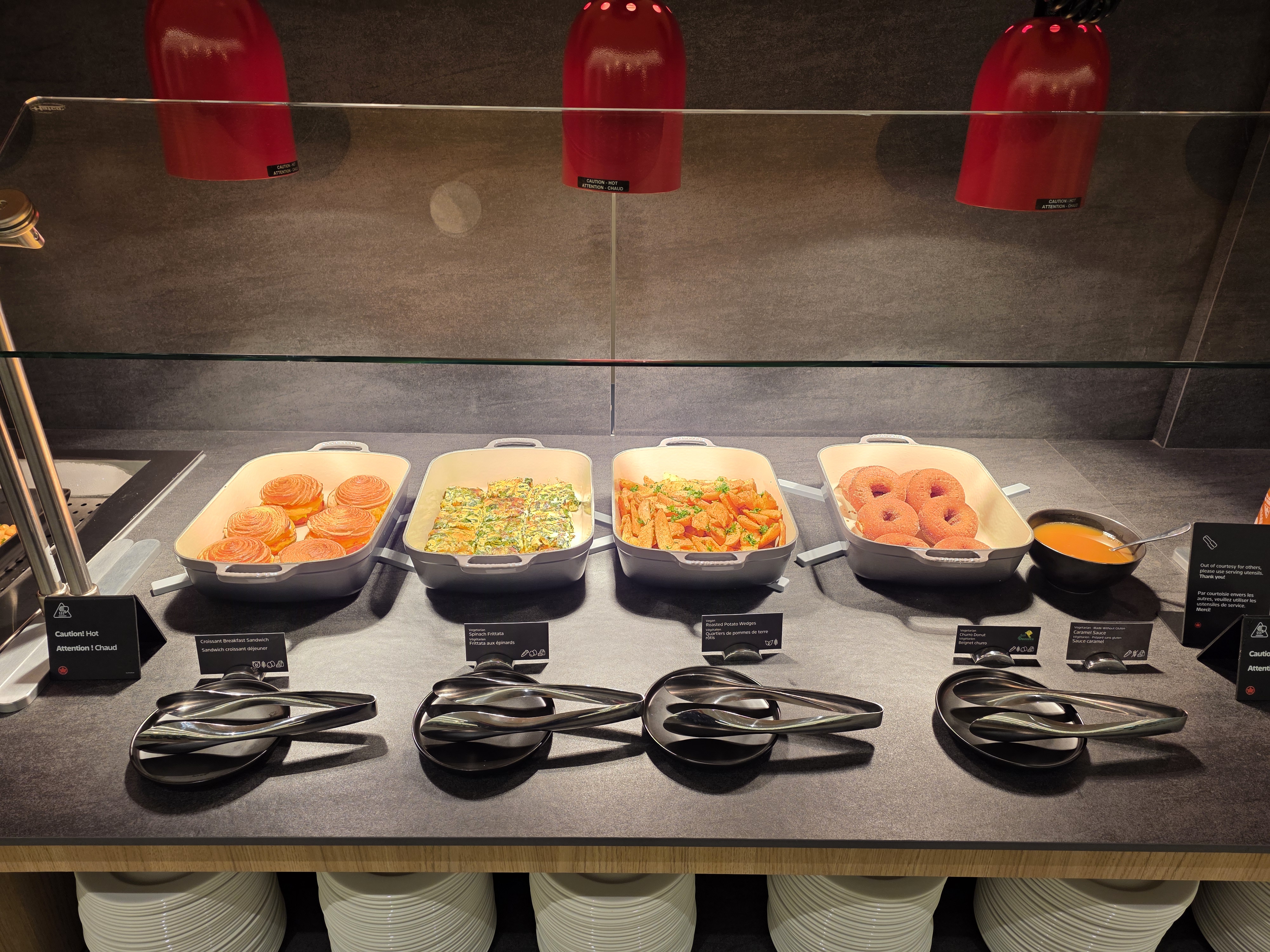 Hot food buffet under red heat lamps at the Air Canada Café YVR