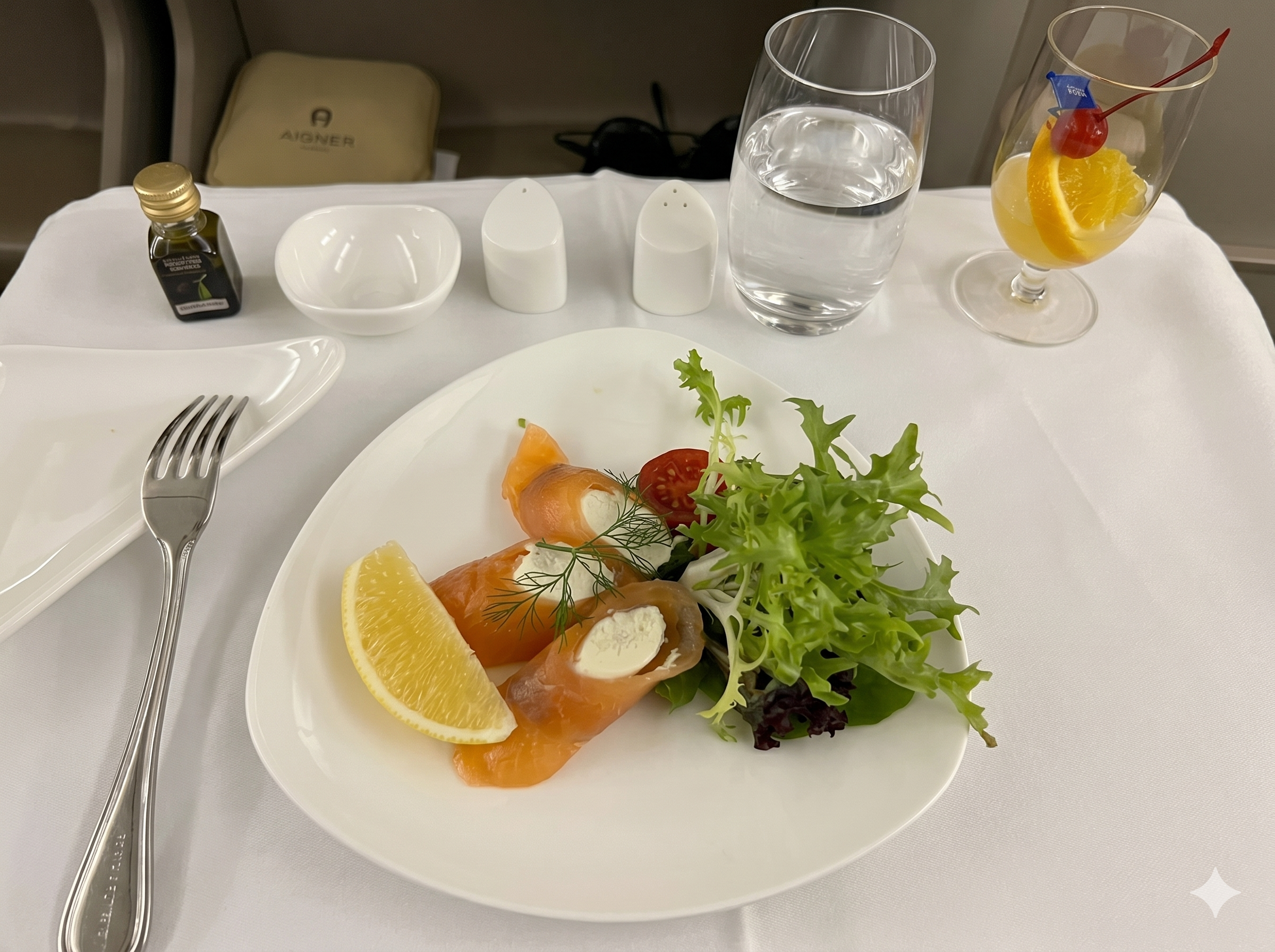 Asiana Airlines business class smoked salmon appetizer with greens and orange slice