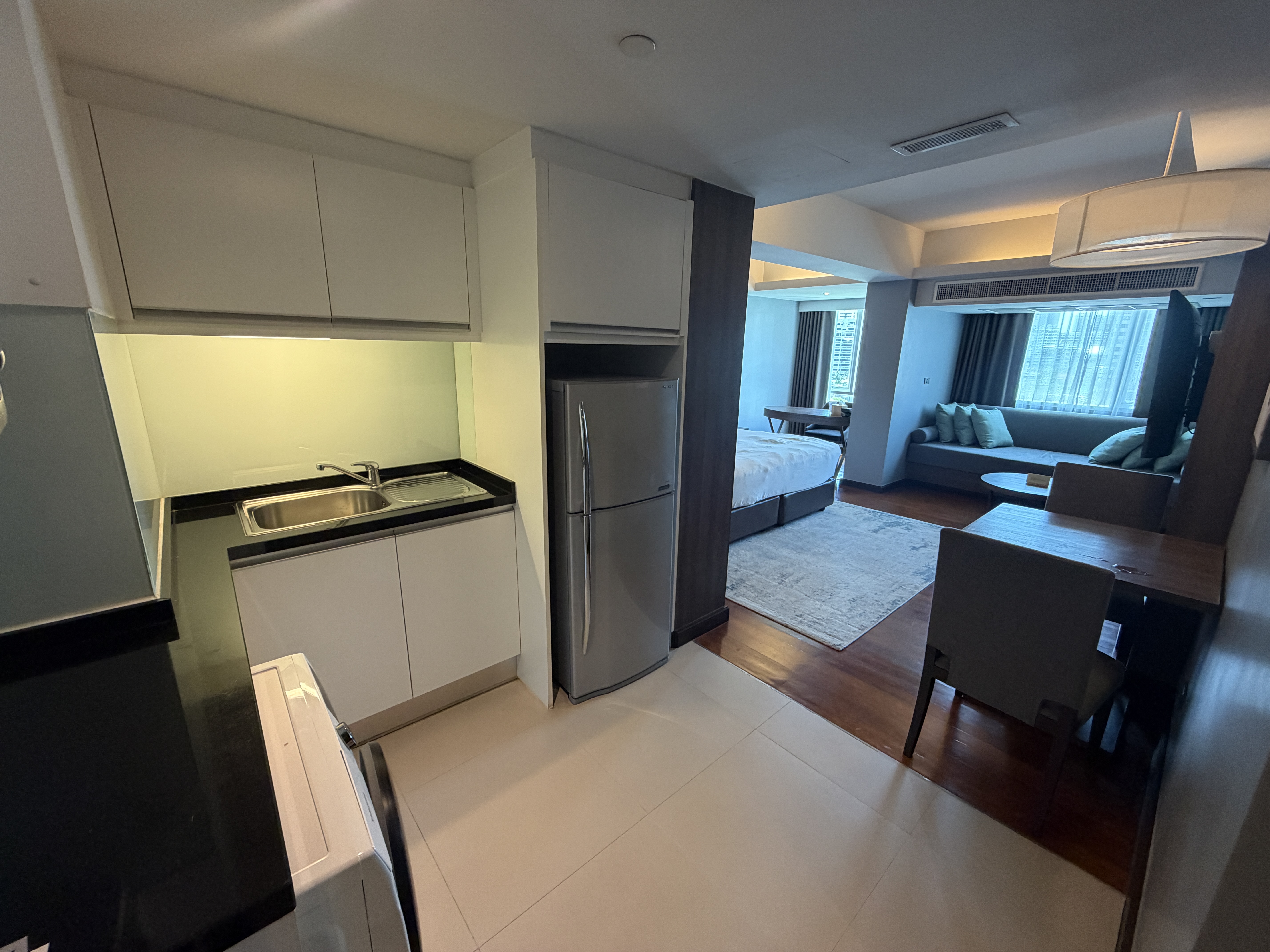Apartment-style Deluxe Studio at Novotel Living Bangkok Sukhumvit Legacy with kitchen and living area