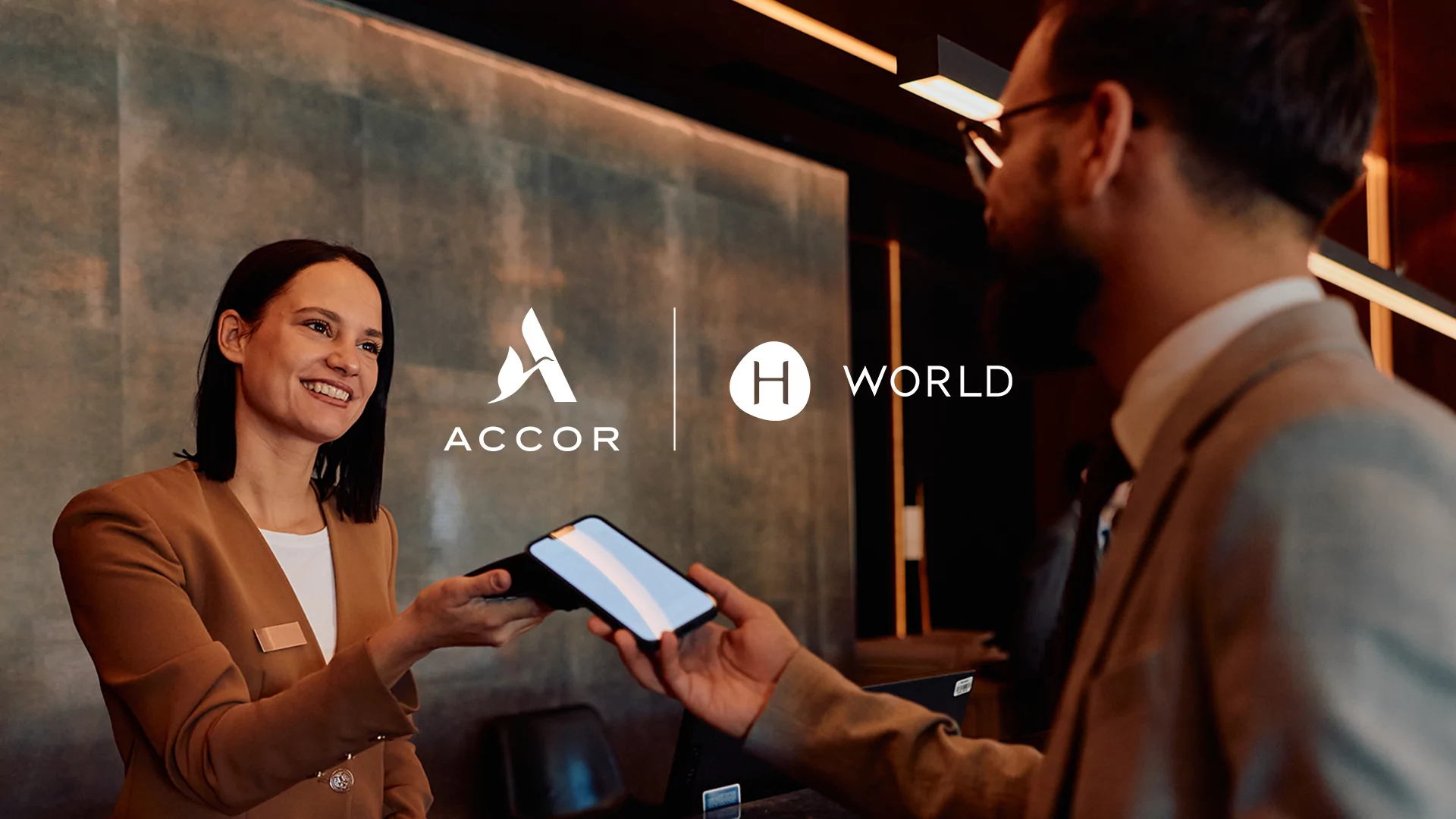 Accor and H World logos over a hotel front desk scene, from the partnership announcement