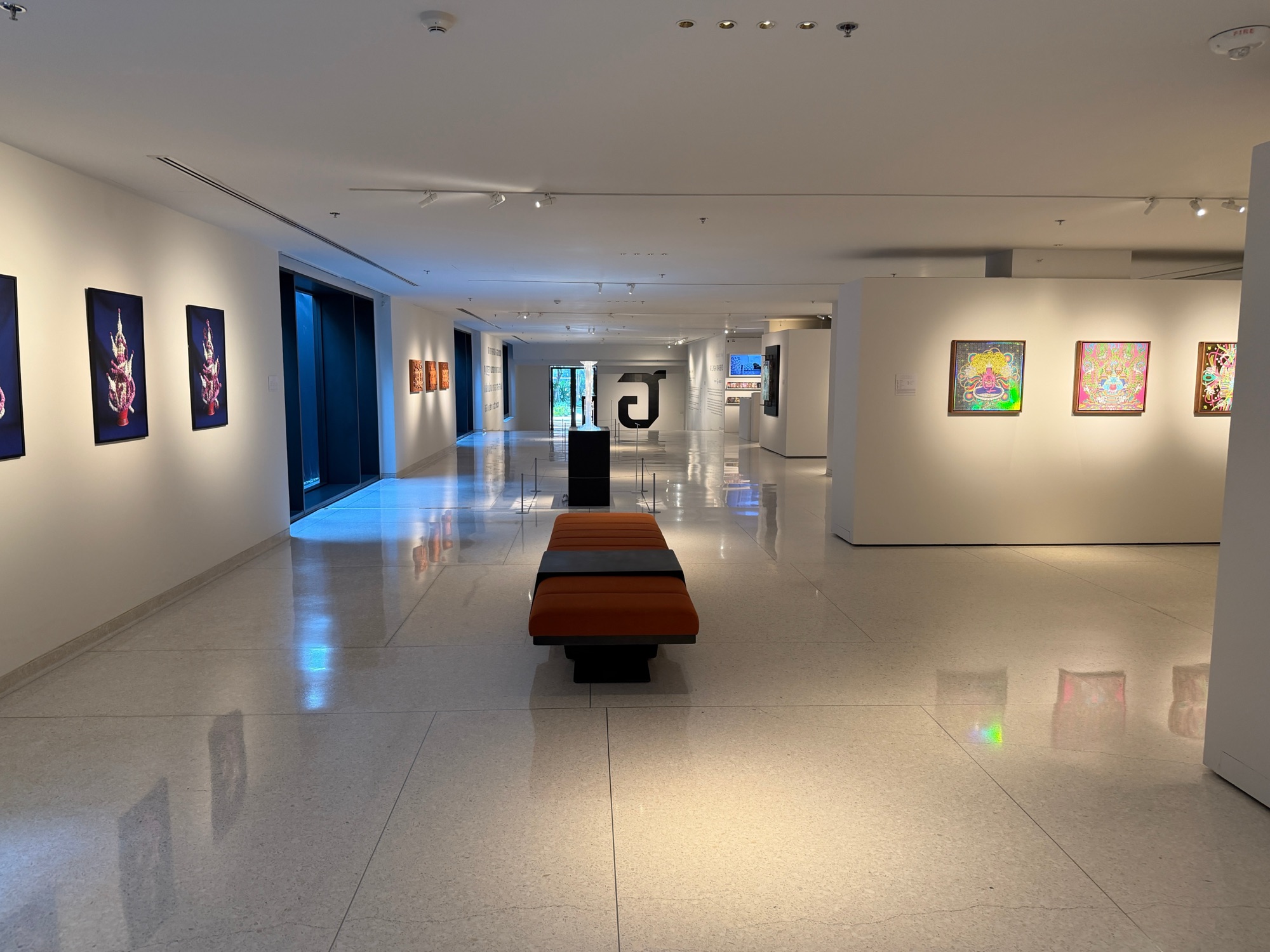On-site art gallery with framed Thai contemporary artworks and a bench at Four Seasons Hotel Bangkok at Chao Phraya River