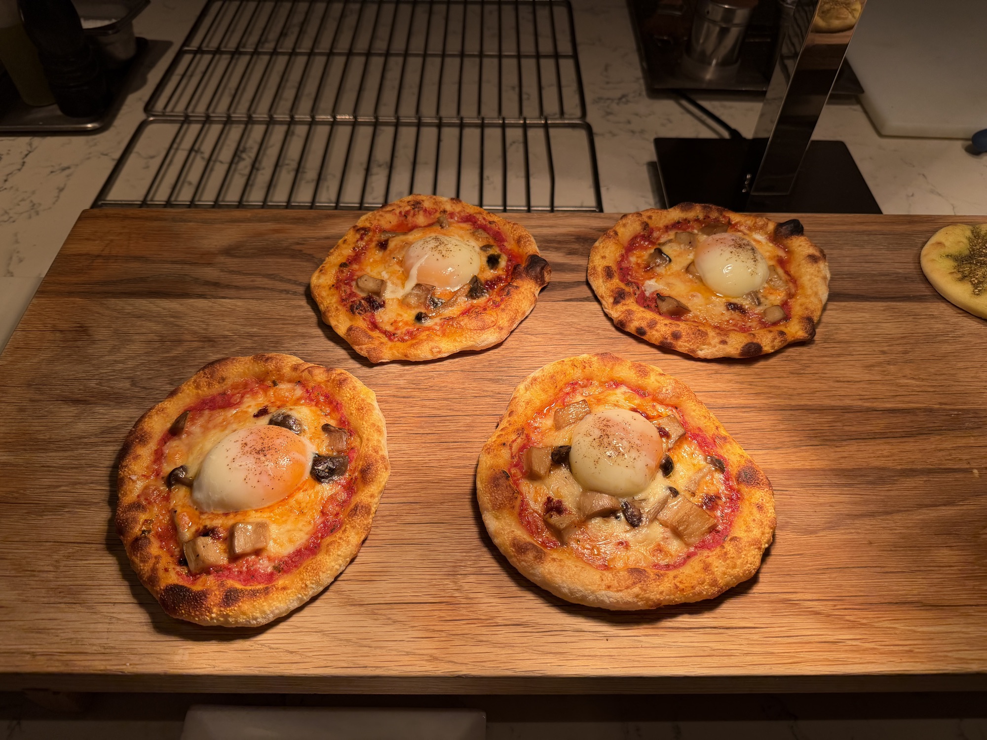Wood-fired mini pizzas topped with egg at the Riva del Fiume breakfast at Four Seasons Hotel Bangkok at Chao Phraya River