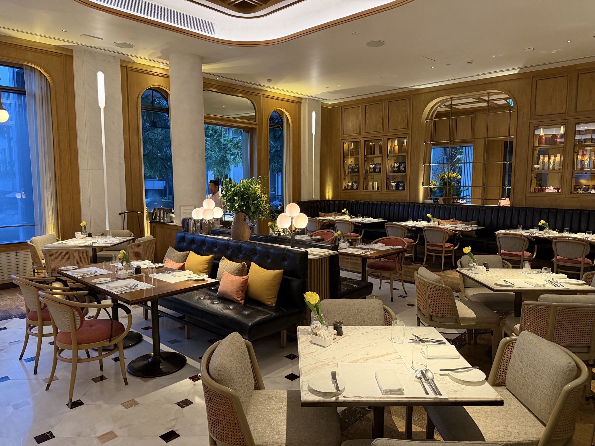 Marble tables line leather banquettes in the dining room. at Four Seasons Hotel Bangkok at Chao Phraya River