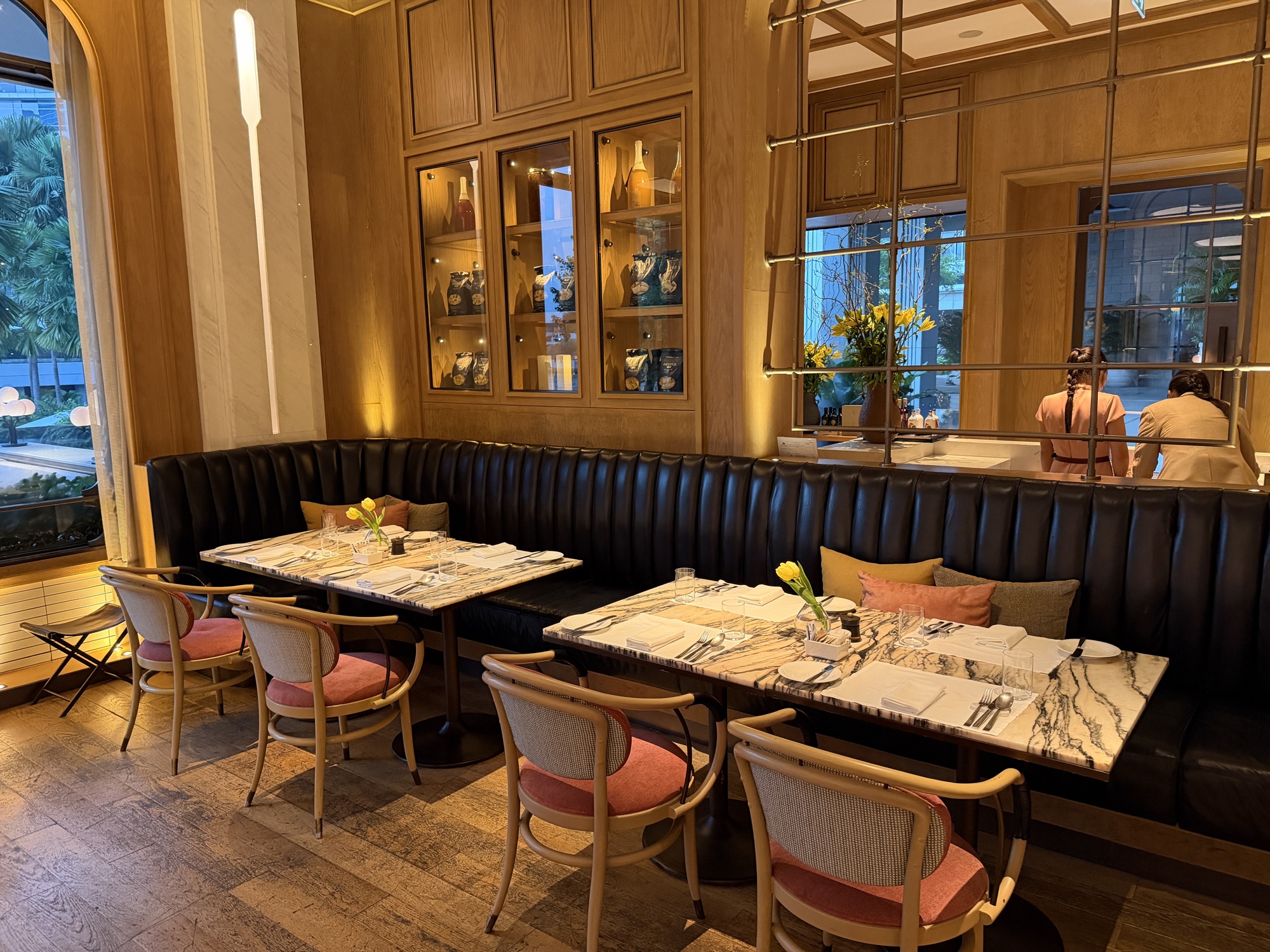 Display cabinets and warm timber frame the seating. at Four Seasons Hotel Bangkok at Chao Phraya River