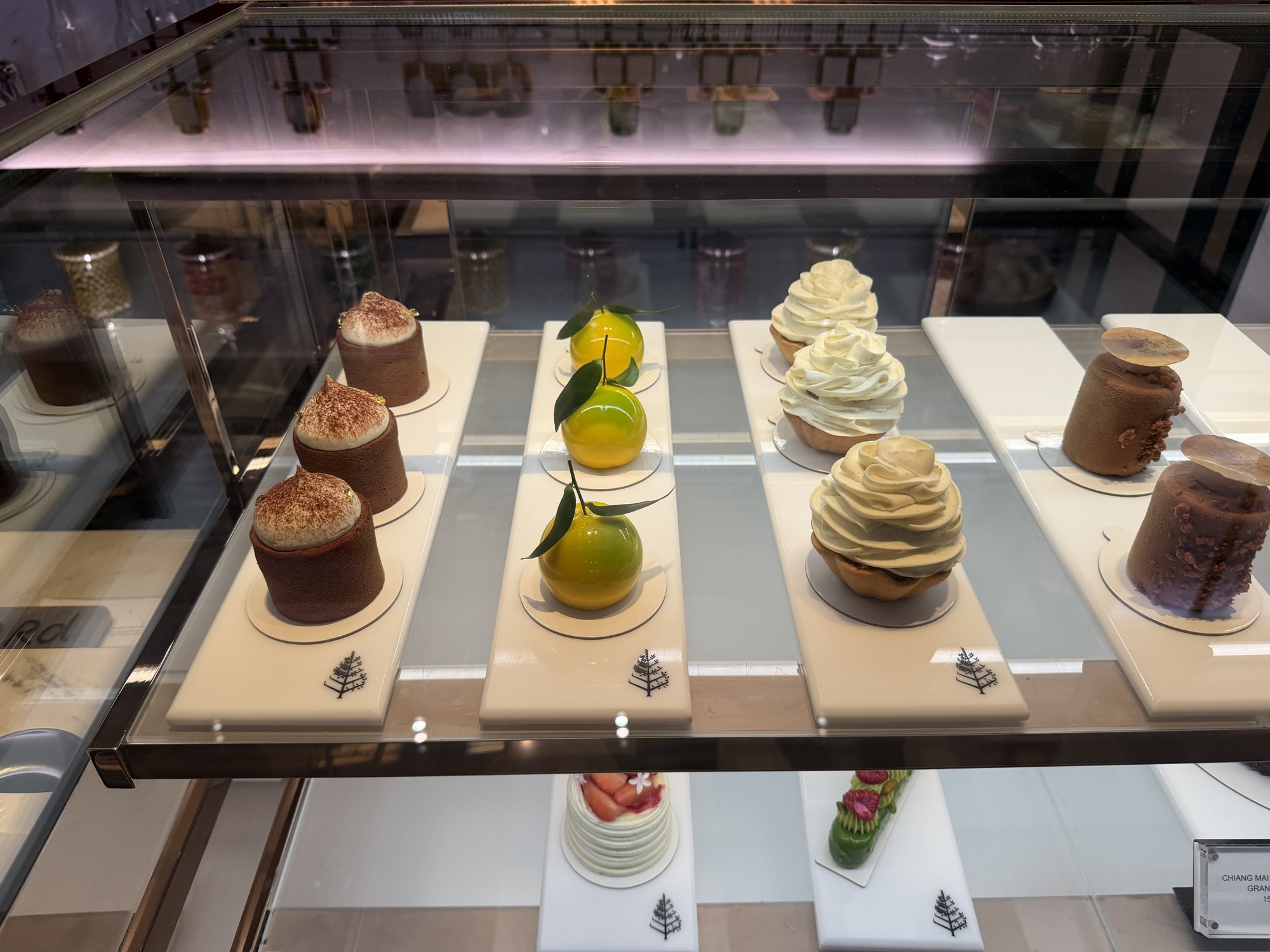 Entremets in the pastry display case at Café Madeleine at Four Seasons Hotel Bangkok at Chao Phraya River