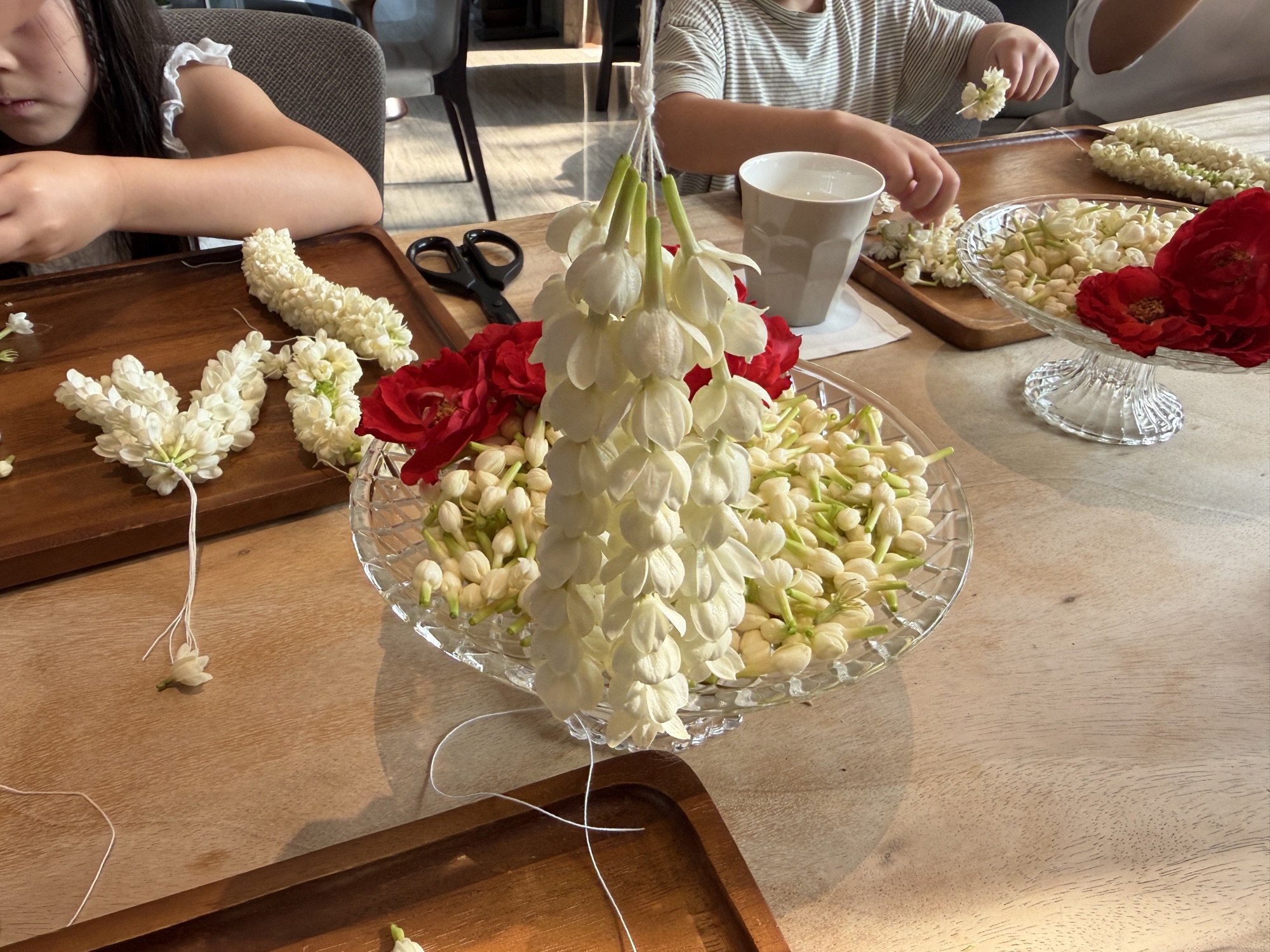 Threading a jasmine phuang malai garland during the Thai cultural activity at Four Seasons Hotel Bangkok at Chao Phraya River