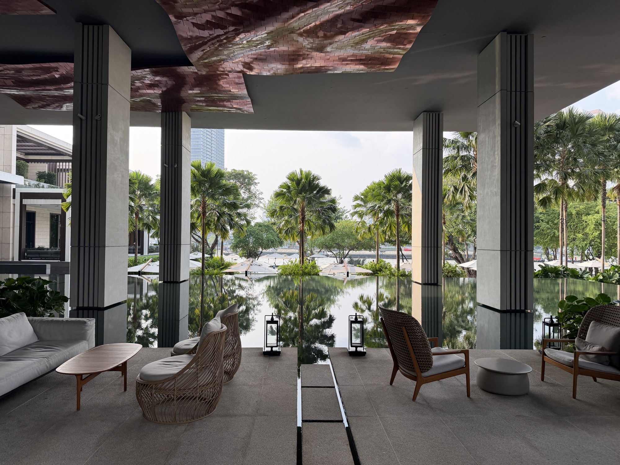 Covered lounge terrace overlooking the palm court reflecting pool at Four Seasons Hotel Bangkok at Chao Phraya River