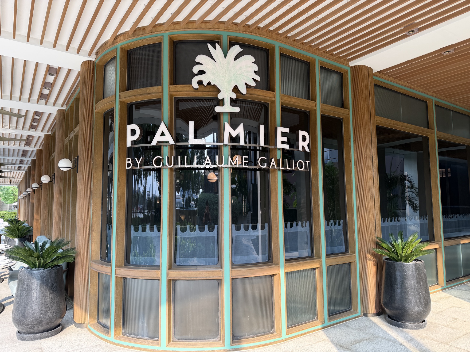 Palmier by Guillaume Galliot restaurant entrance with palm logo at Four Seasons Hotel Bangkok at Chao Phraya River