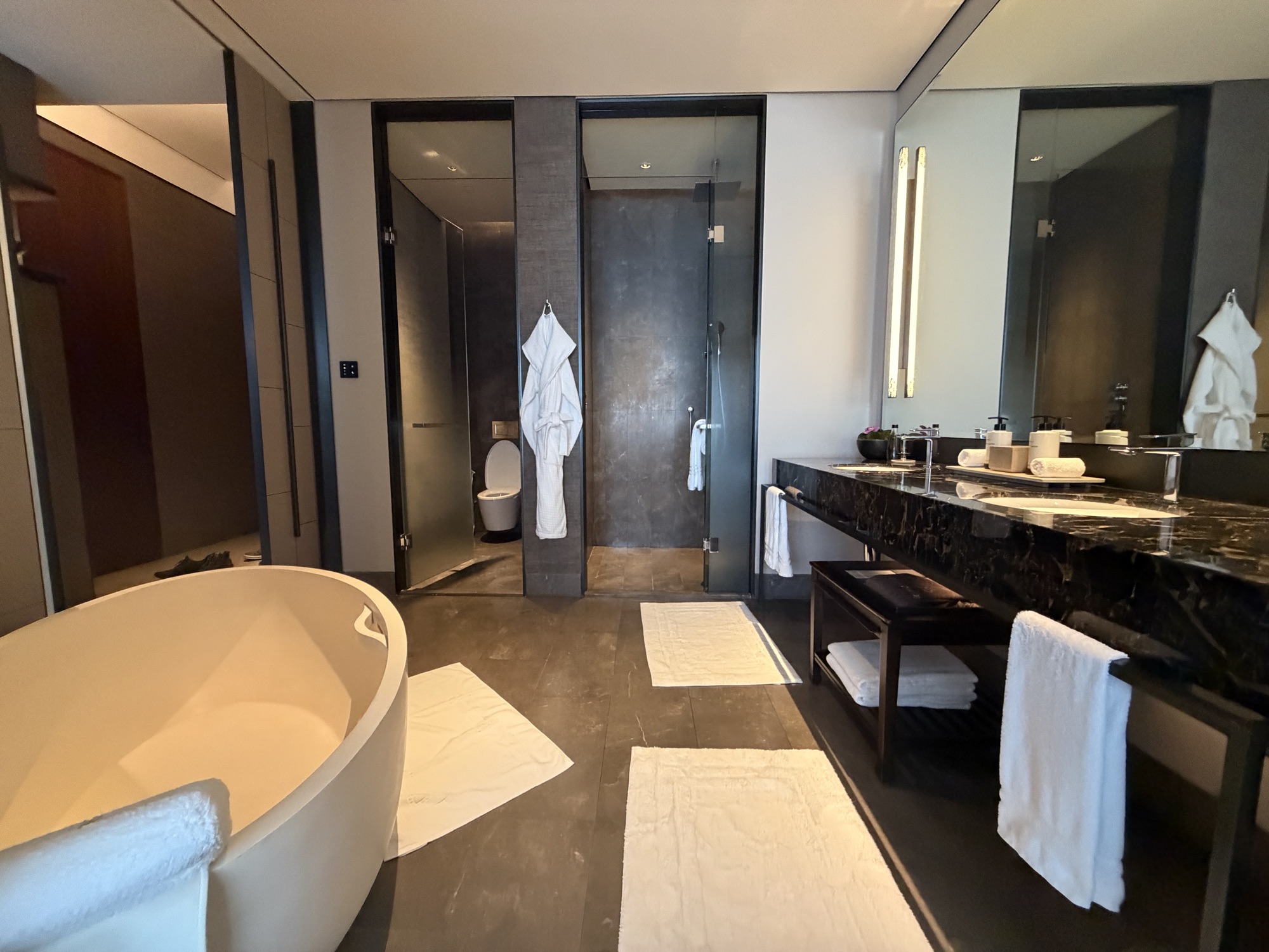 Bathroom with oval tub, robes, and double vanity in the Deluxe River-View Room at Four Seasons Hotel Bangkok at Chao Phraya River