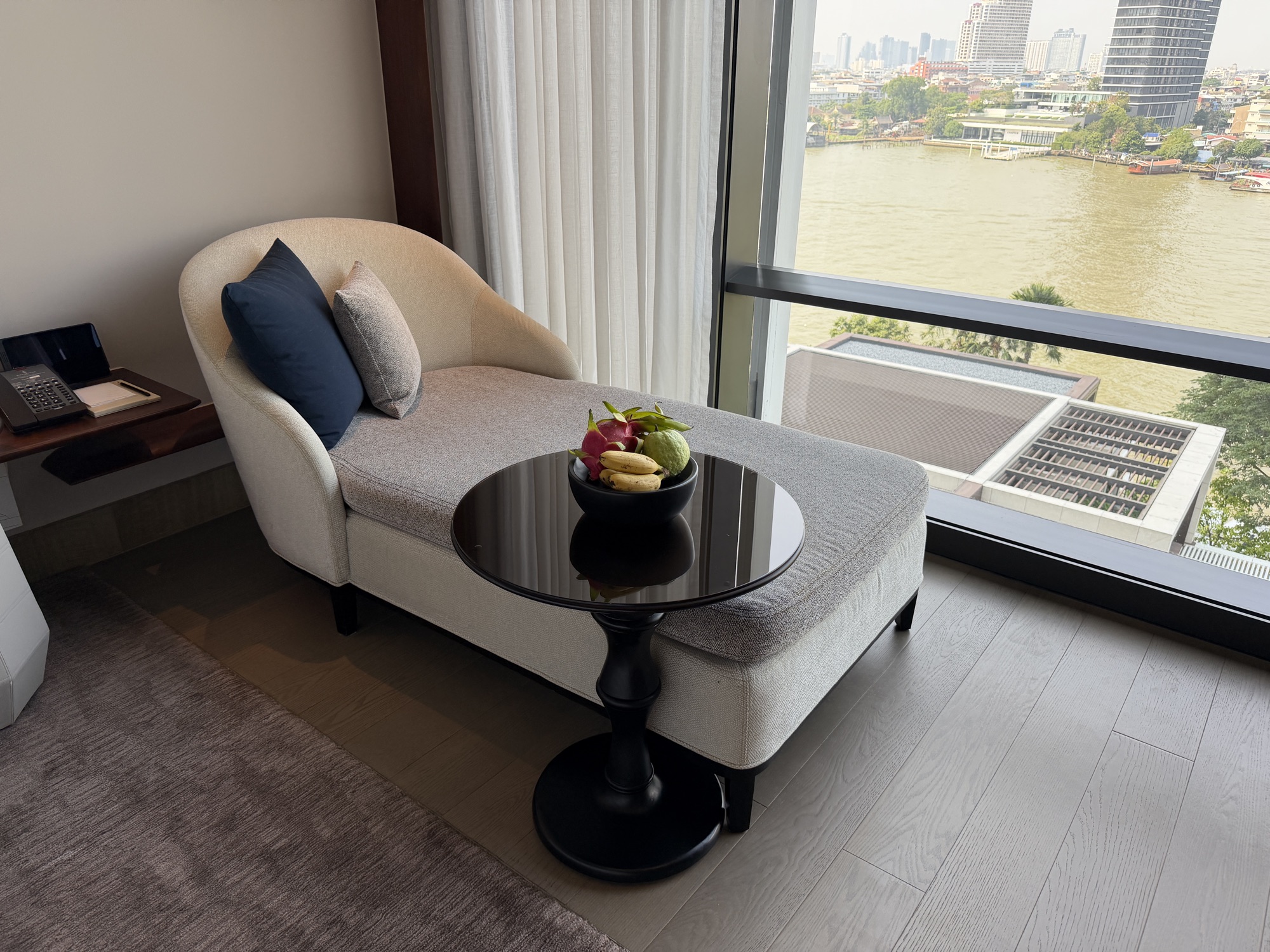 Chaise lounge by the window with river views in the Deluxe River-View Room at Four Seasons Hotel Bangkok at Chao Phraya River