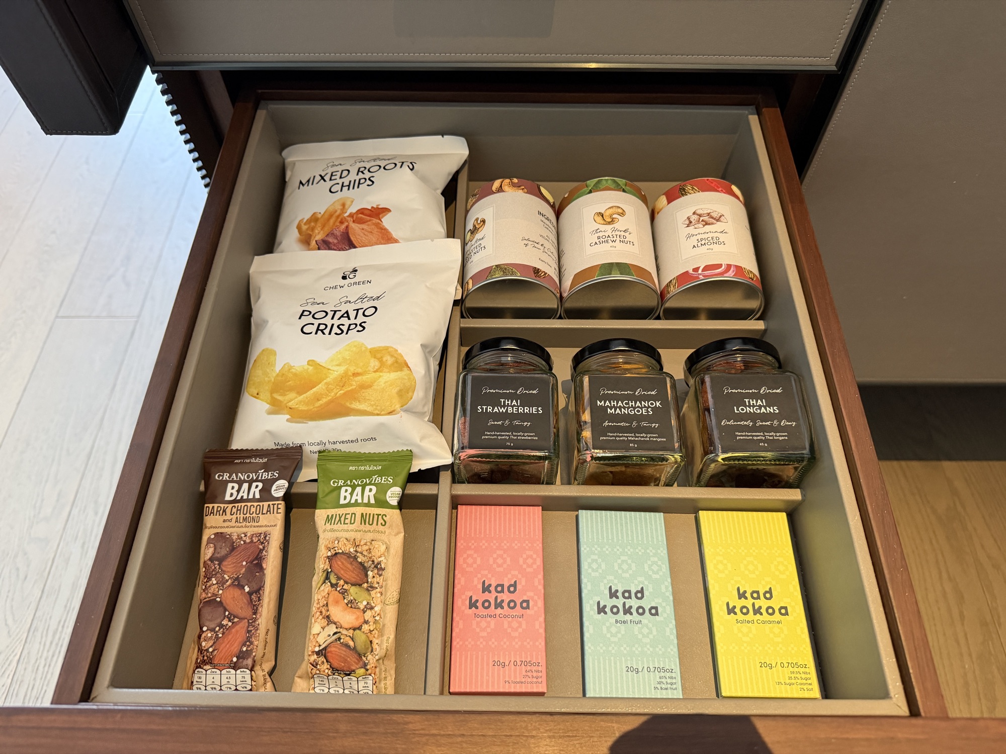 Snack drawer with chips, nuts, and kad kokoa chocolate in the Deluxe River-View Room at Four Seasons Hotel Bangkok at Chao Phraya River