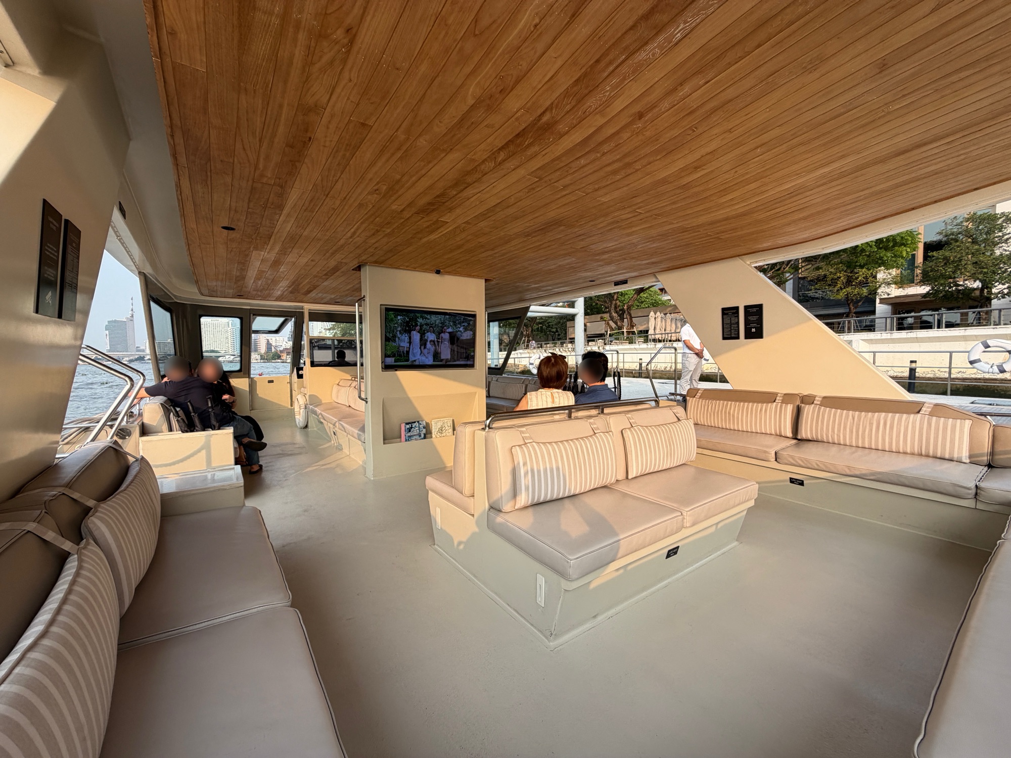 Spacious cushioned cabin of the Chao Phraya Estate shuttle boat at Four Seasons Hotel Bangkok at Chao Phraya River