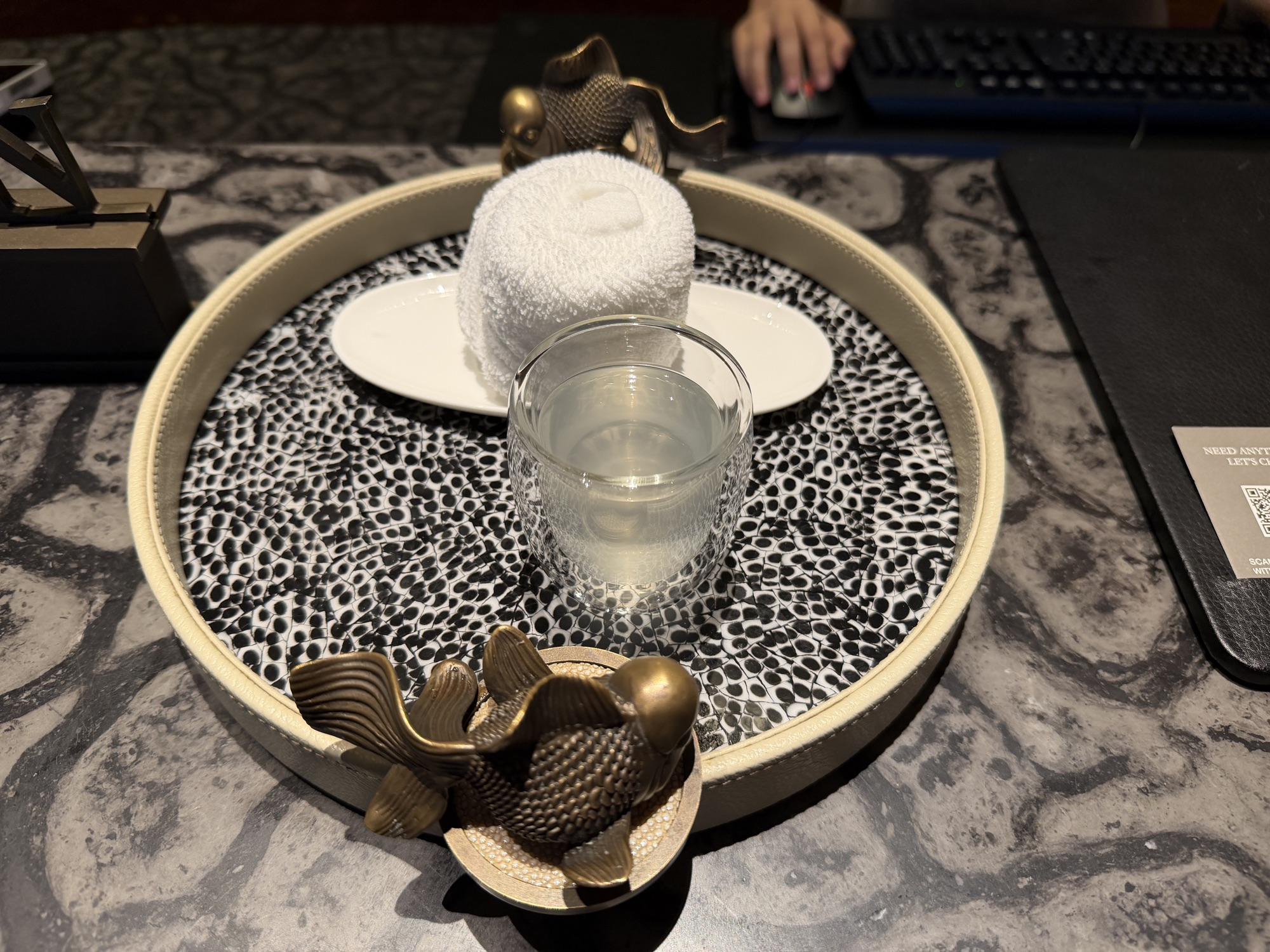 Rolled chilled towel and welcome tea on a koi-decorated tray at check-in at Four Seasons Hotel Bangkok at Chao Phraya River
