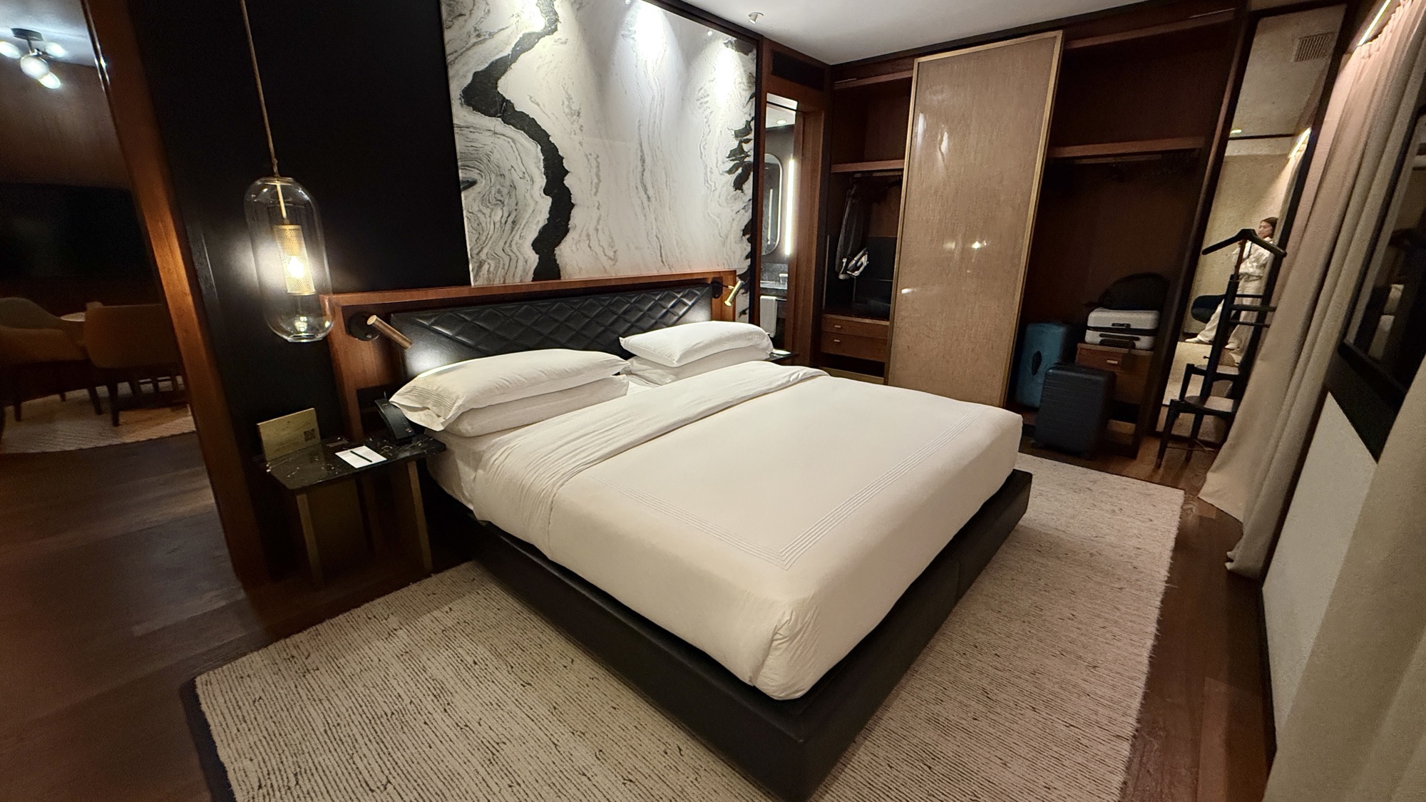 Corner Suite king bed against a veined marble feature wall