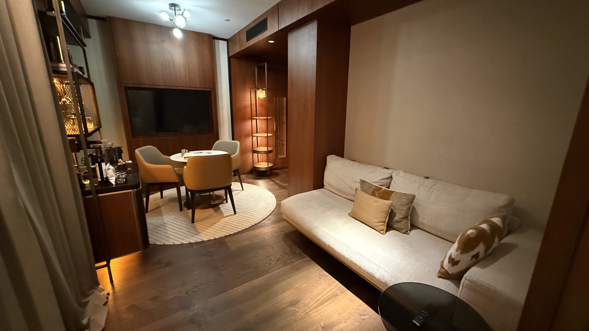 Corner Suite living room with sofa, wall-mounted television, and marble feature wall