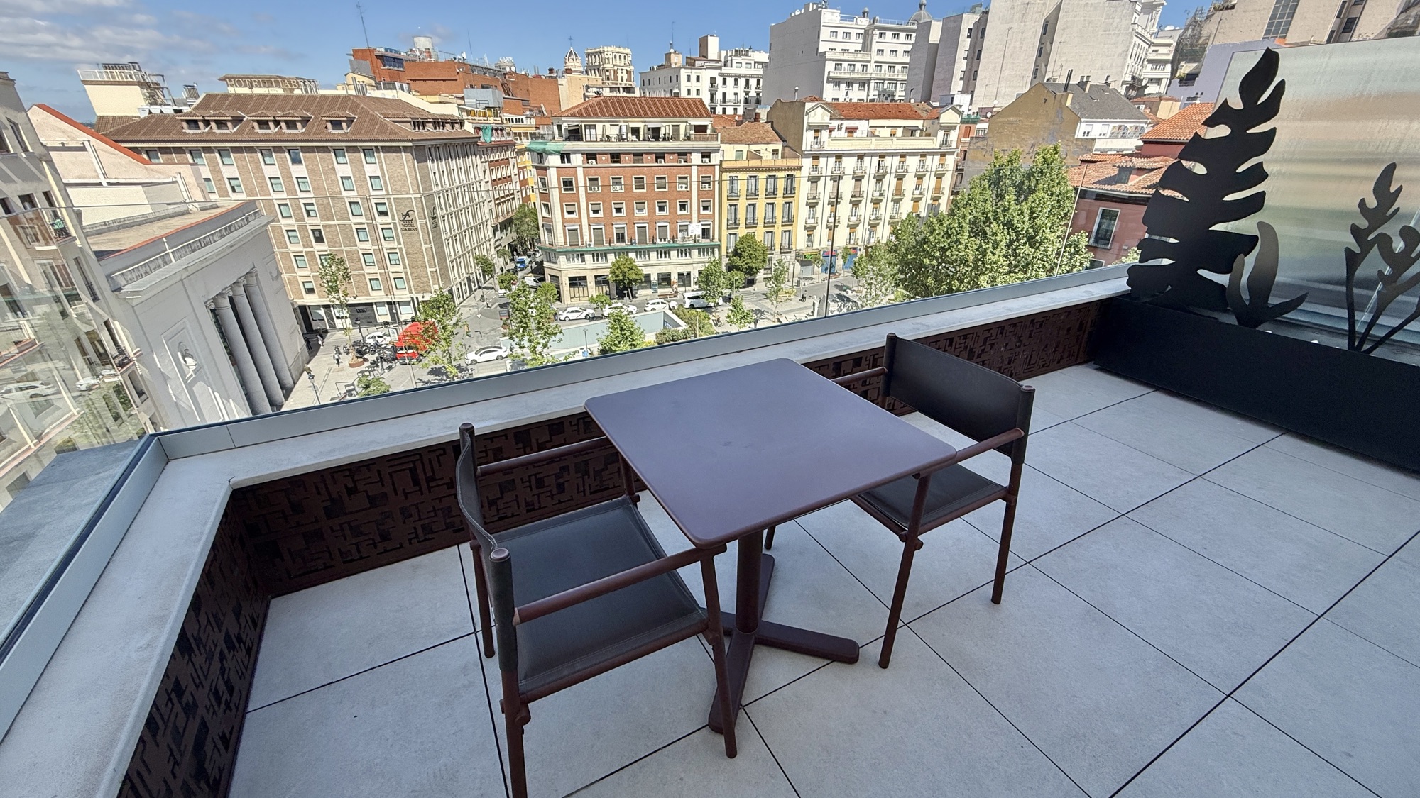 Private suite terrace with a table and chairs overlooking the plaza