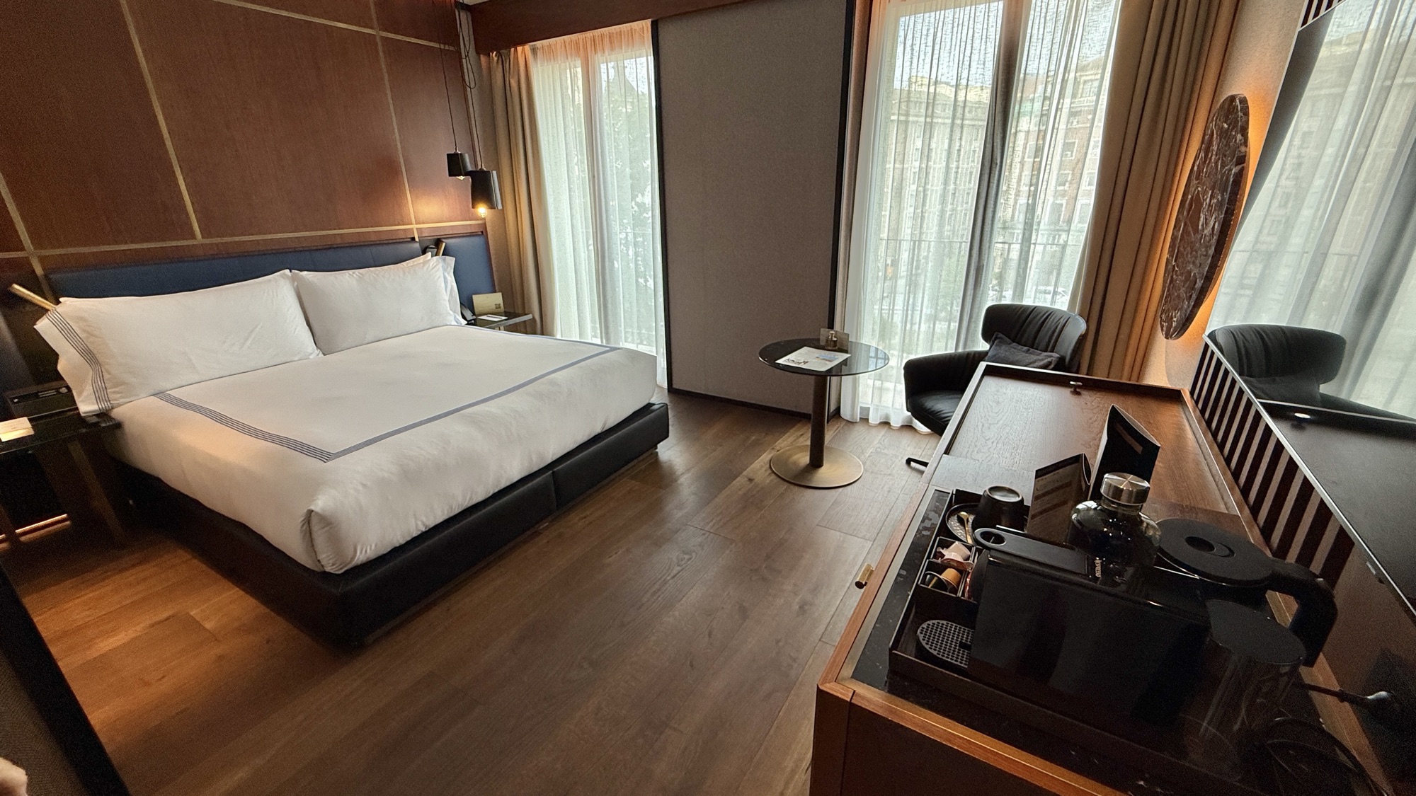 Junior Suite king bed with a seating area and desk by the window