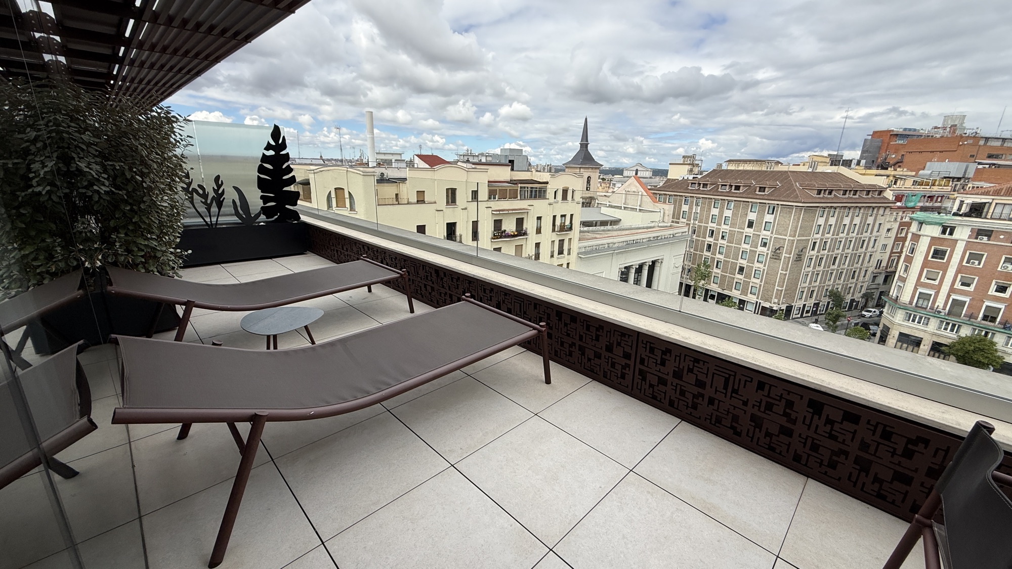 Large Junior Suite terrace with loungers and Madrid skyline views