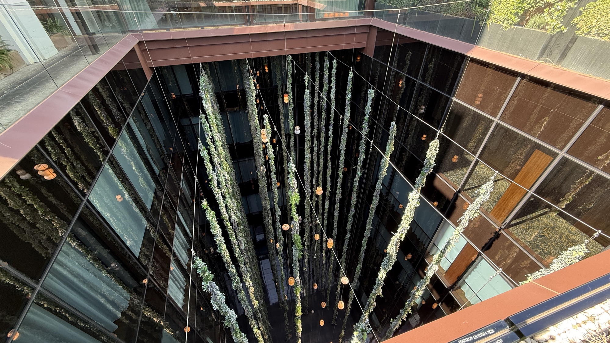 Vertical garden of hanging greenery in a mirrored light well at Thompson Madrid