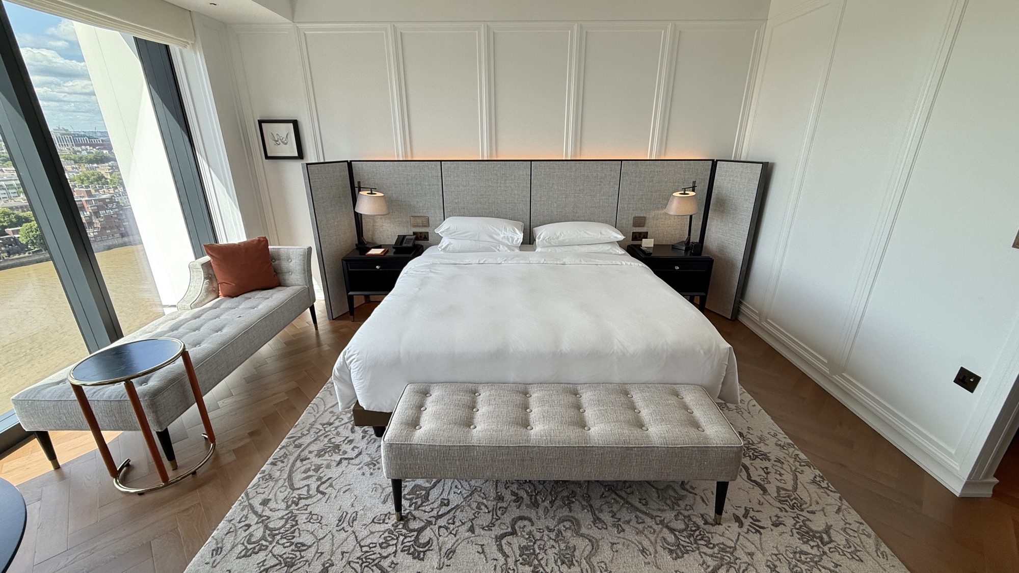 King bed with upholstered bench and patterned rug in the King Bed River View room