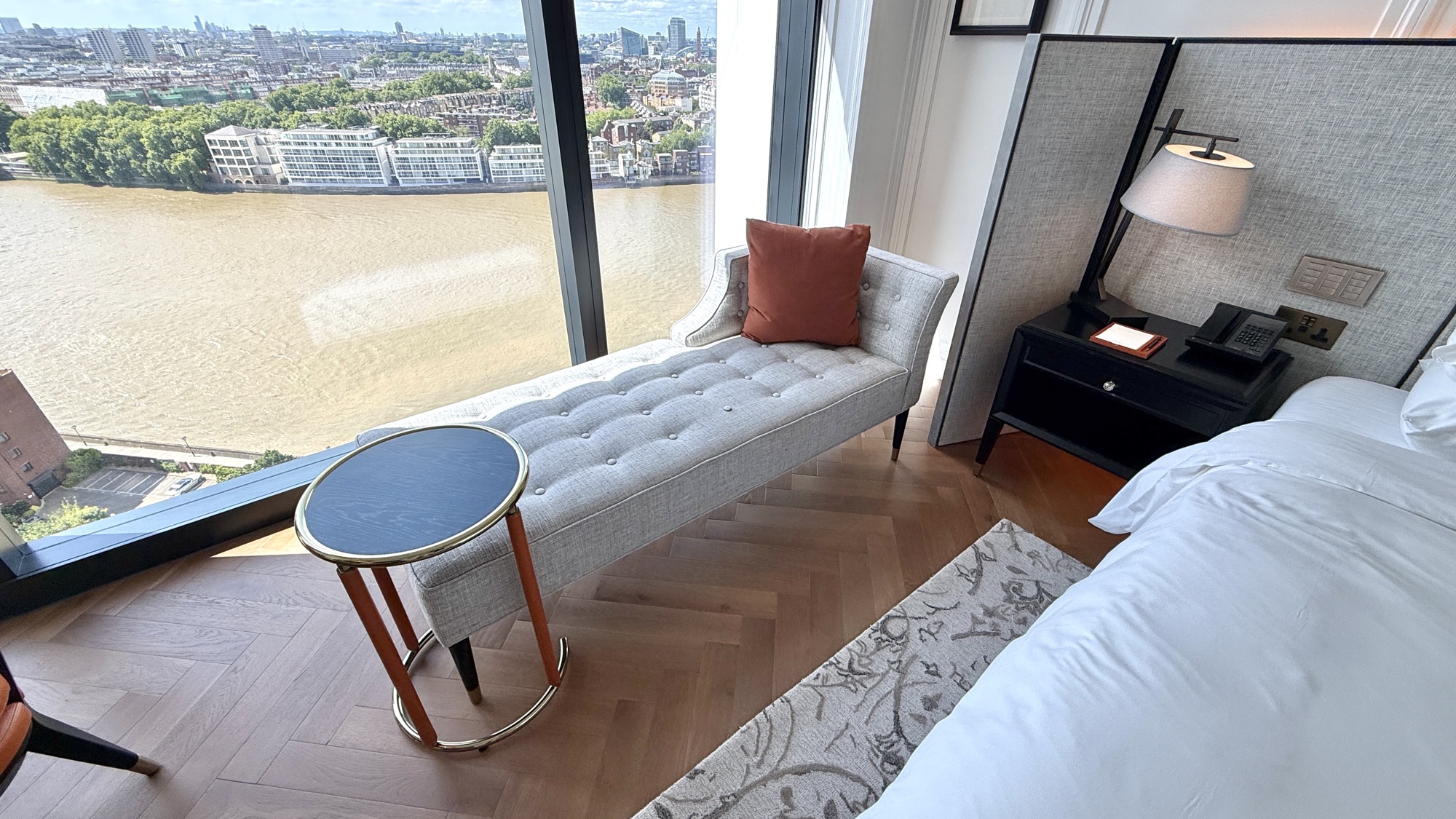Chaise longue beside floor-to-ceiling windows overlooking the River Thames in the River View room