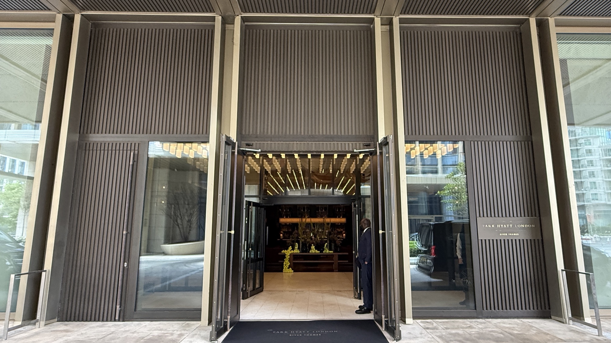 Main entrance of the Park Hyatt London River Thames with open timber doors and a doorman