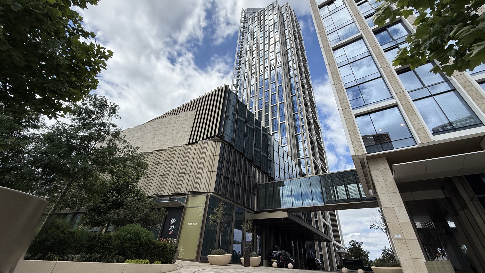 Exterior of the Park Hyatt London River Thames tower in Nine Elms, seen from street level with trees in the foreground