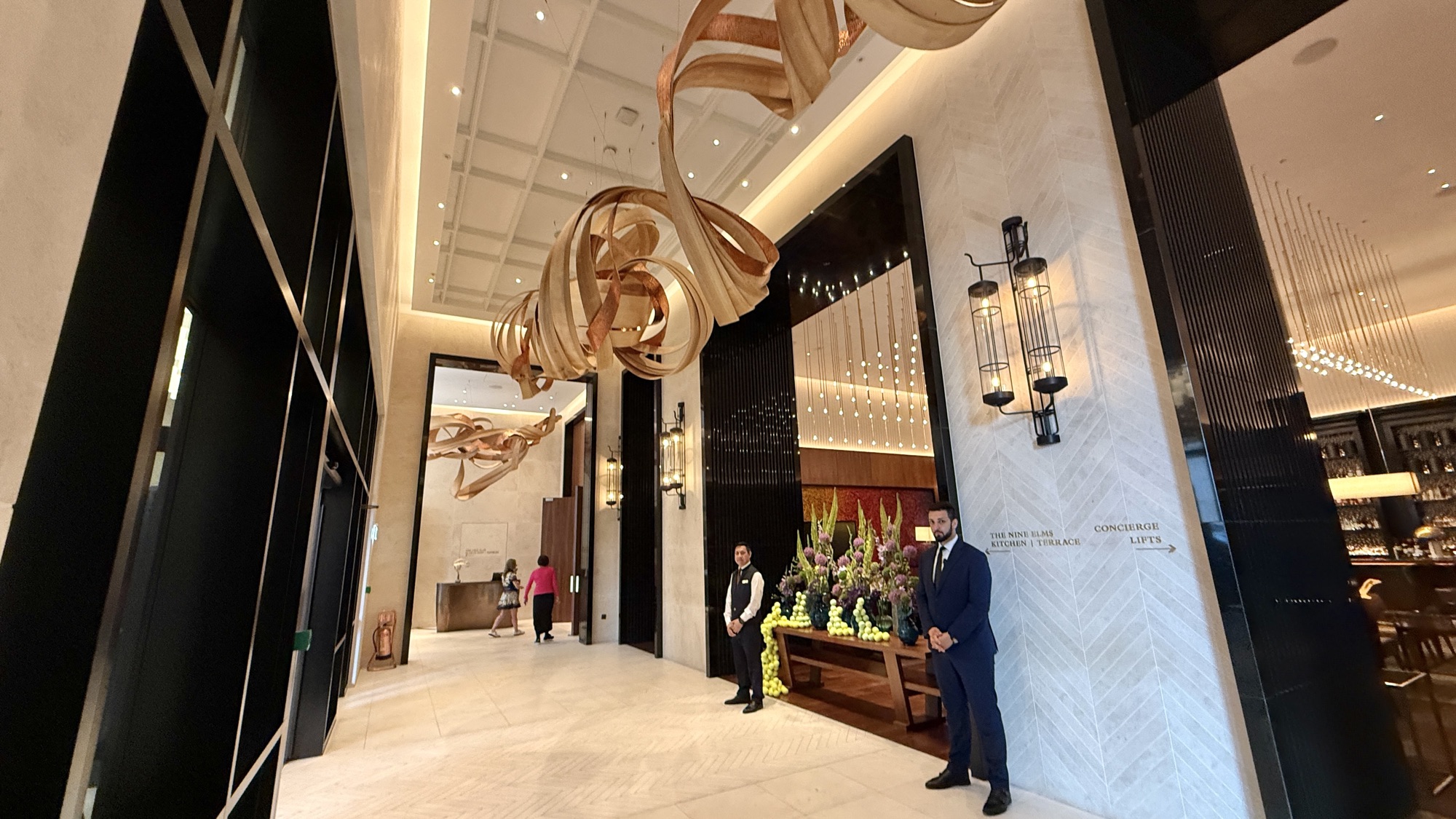 Park Hyatt London River Thames lobby with herringbone stone floor, the copper sculpture, and staff at the concierge
