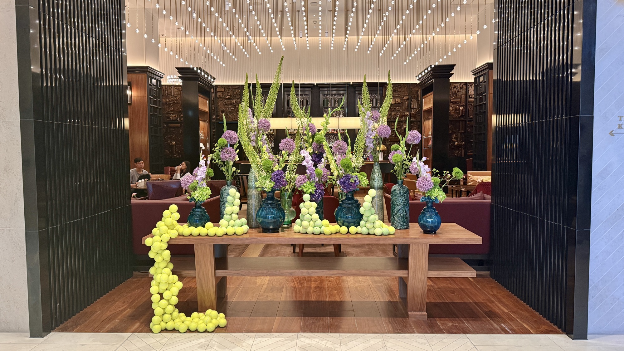 Tall floral arrangements and a green-fruit display on the lobby table at Park Hyatt London River Thames