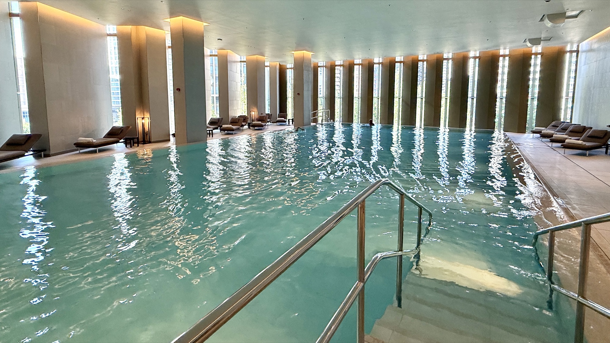Indoor infinity pool with loungers along the side at Park Hyatt London River Thames