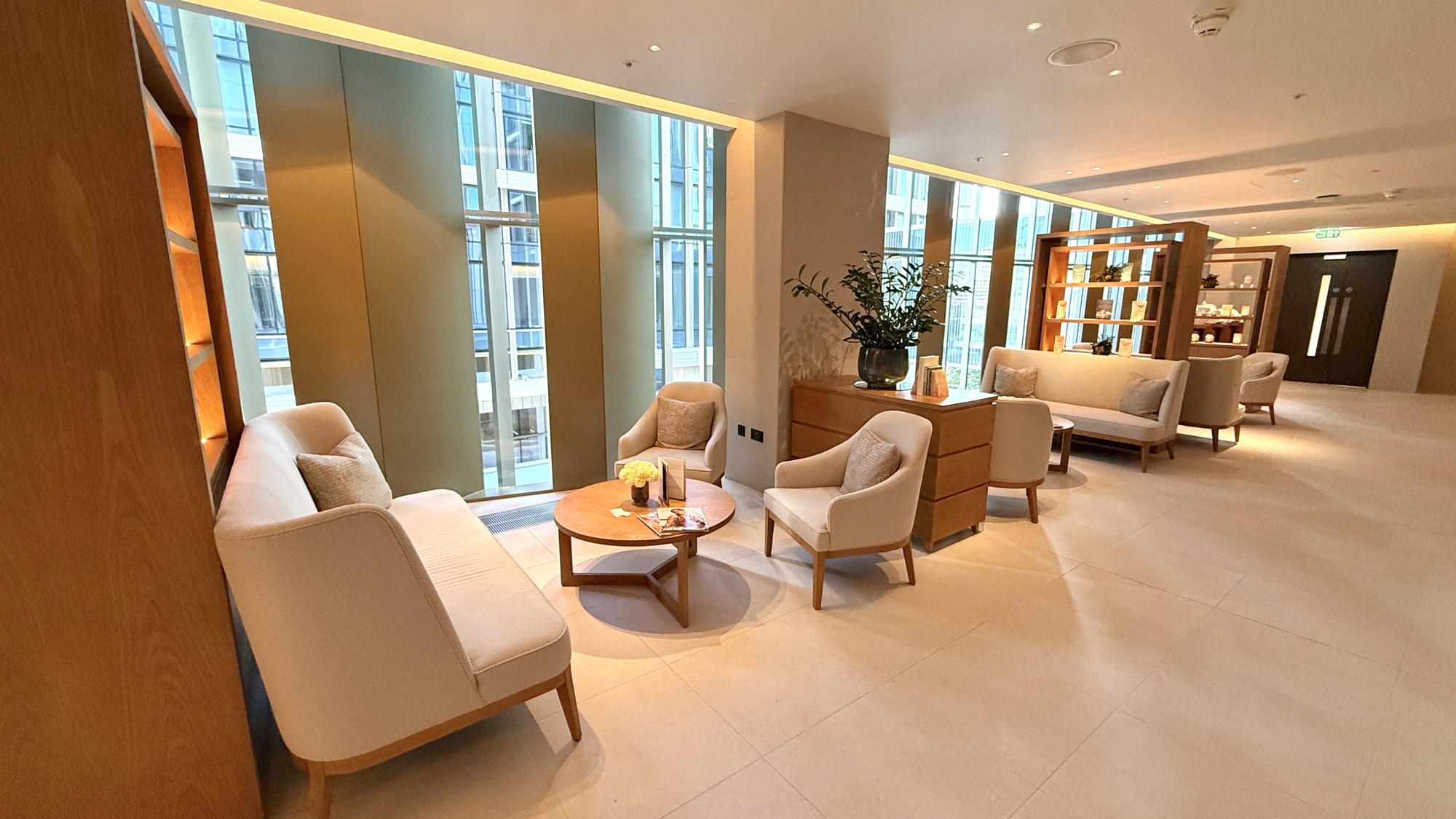 Spa relaxation lounge with cream armchairs and large windows