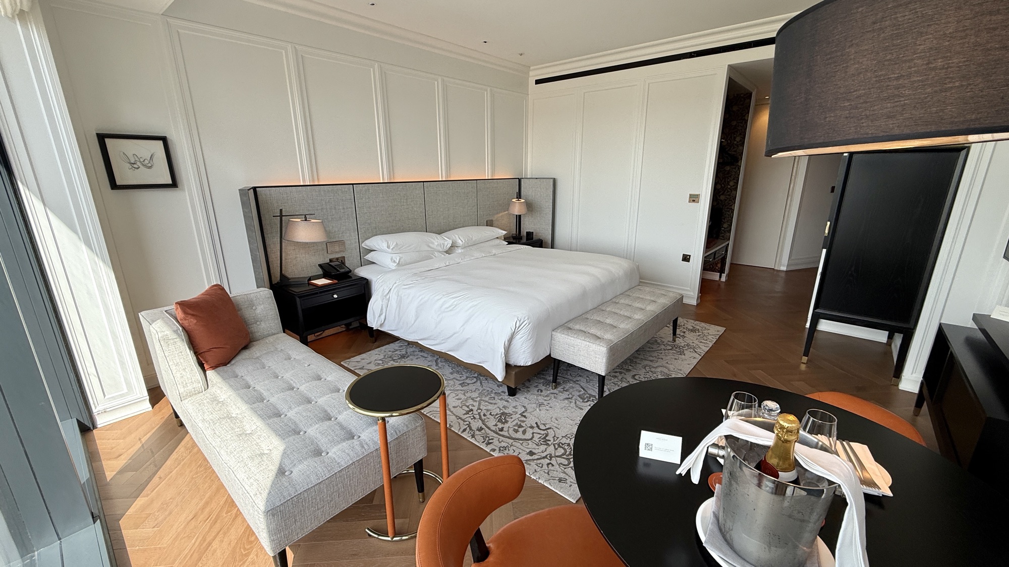 Bottle of wine chilling in an ice bucket on the table in the River View room, with the chaise and bed behind