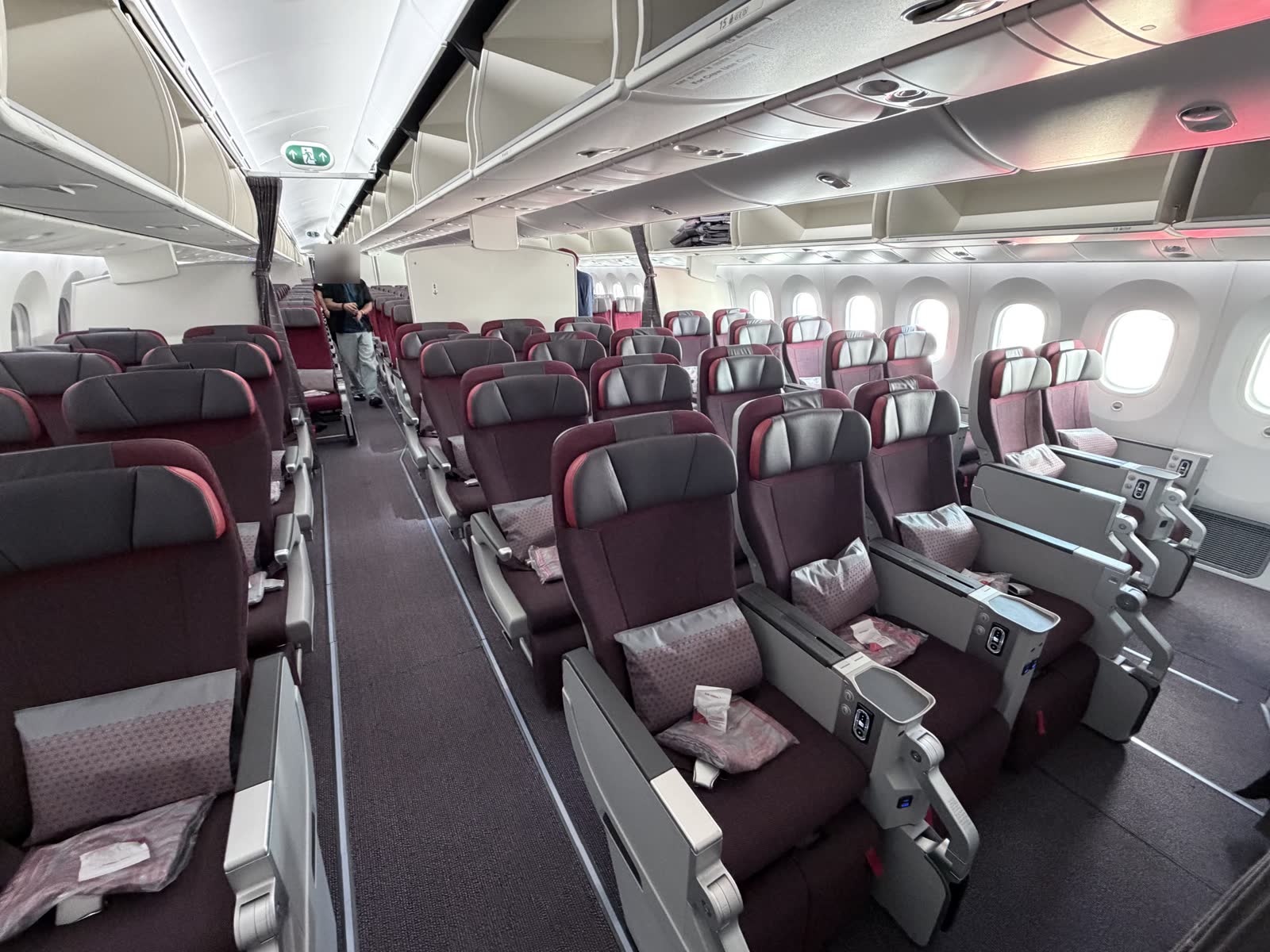 Air India 787-9 premium economy cabin in a 2-3-2 layout, with burgundy seats, grey headrests, and a pillow and blanket on each seat