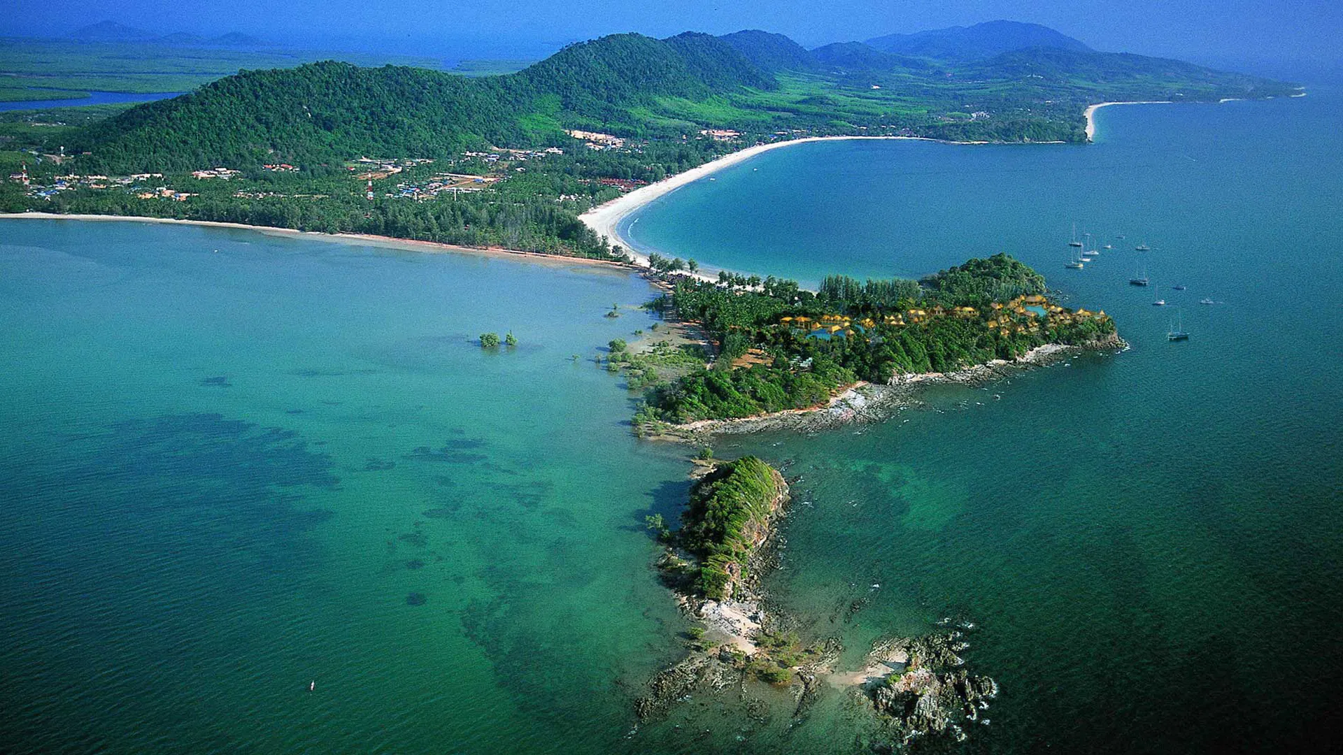 Aerial view of Avani+ Koh Lanta Krabi Resort on a green headland on Koh Lanta, Thailand