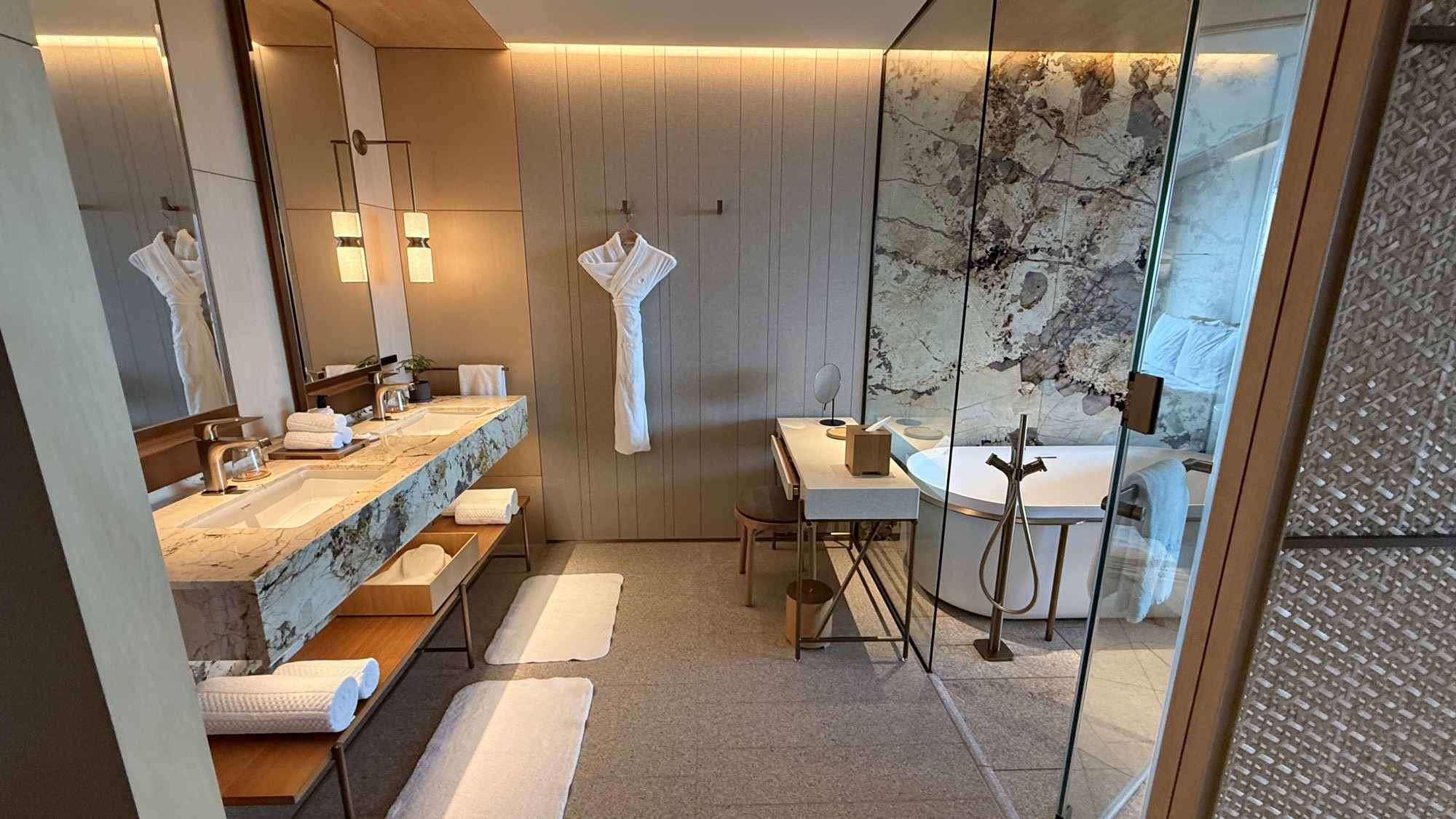 Double vanity and glazed wet area with stone wall and city view