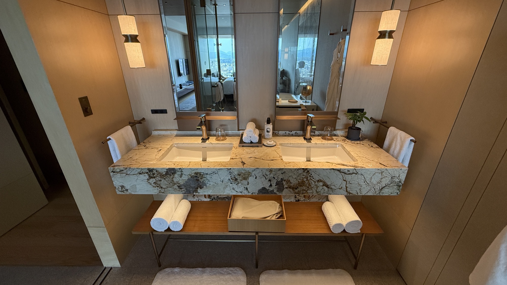 Double vanity with stone counter, twin basins and rolled towels