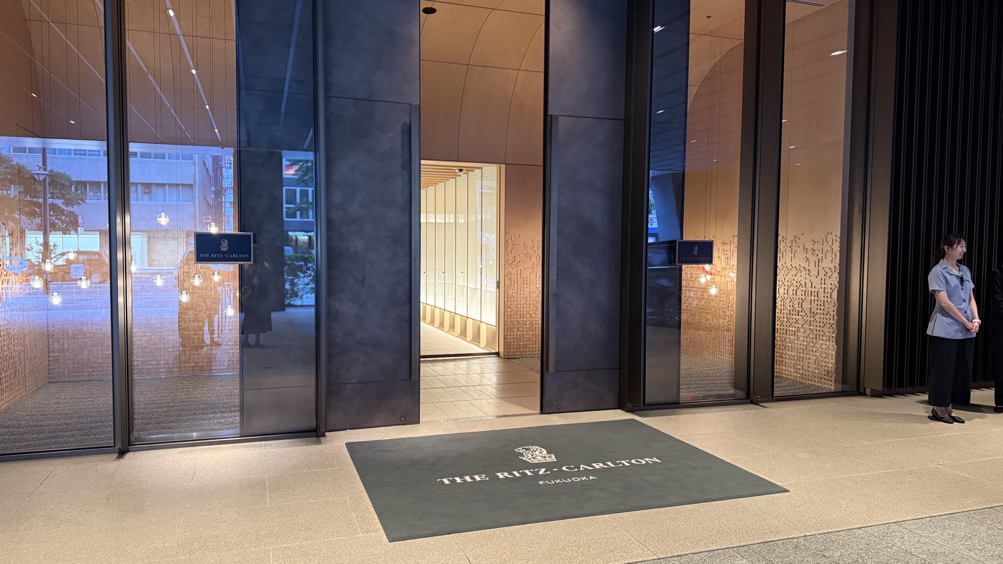 Glass entrance doors and branded floor mat at the street entrance