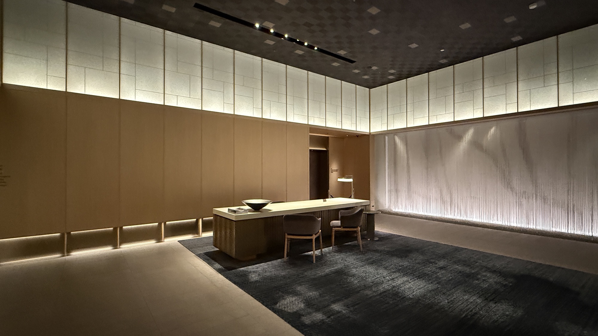 Ground floor reception desk set against a backlit screen wall