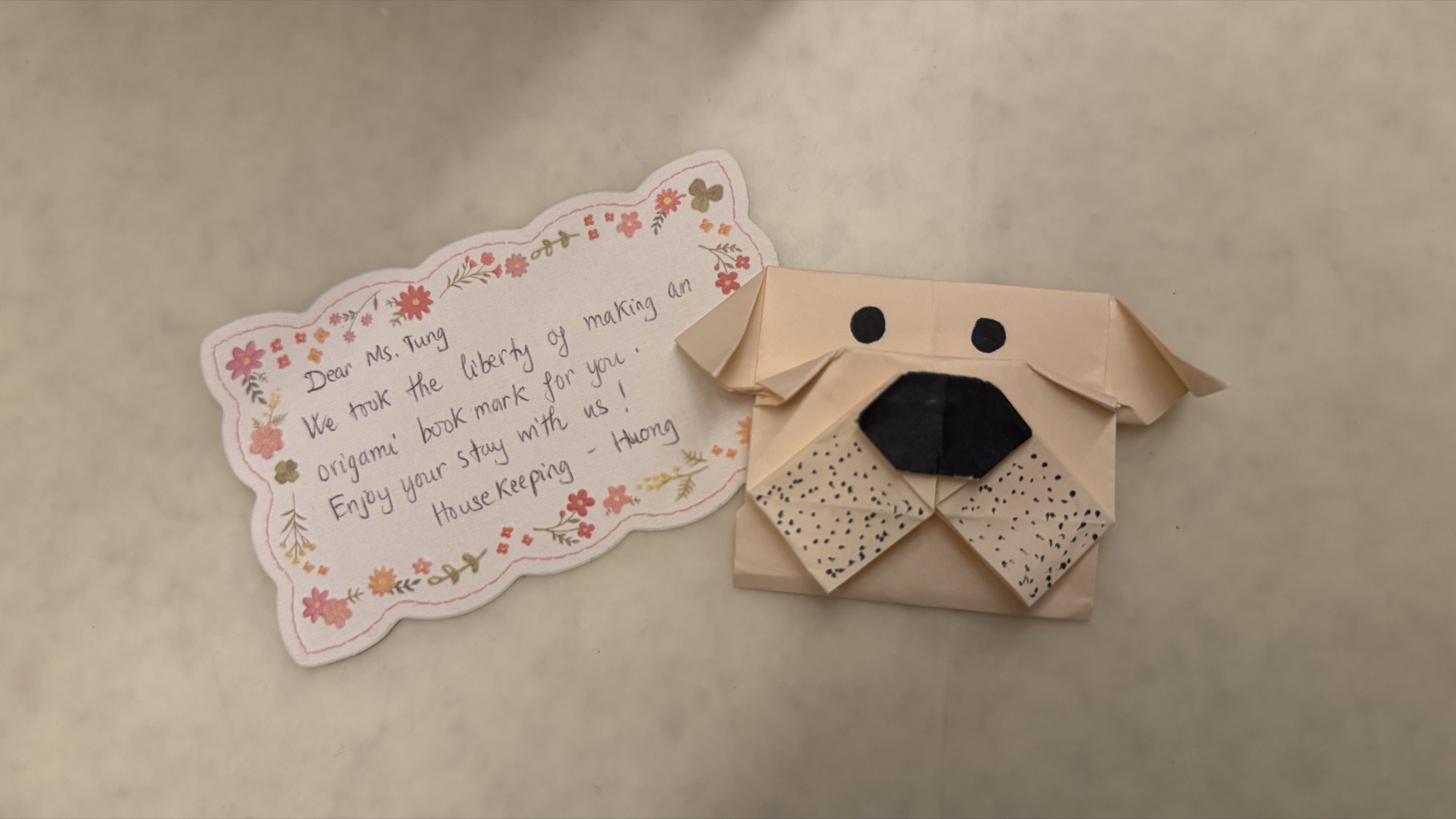 An origami dog folded by housekeeping with a handwritten note