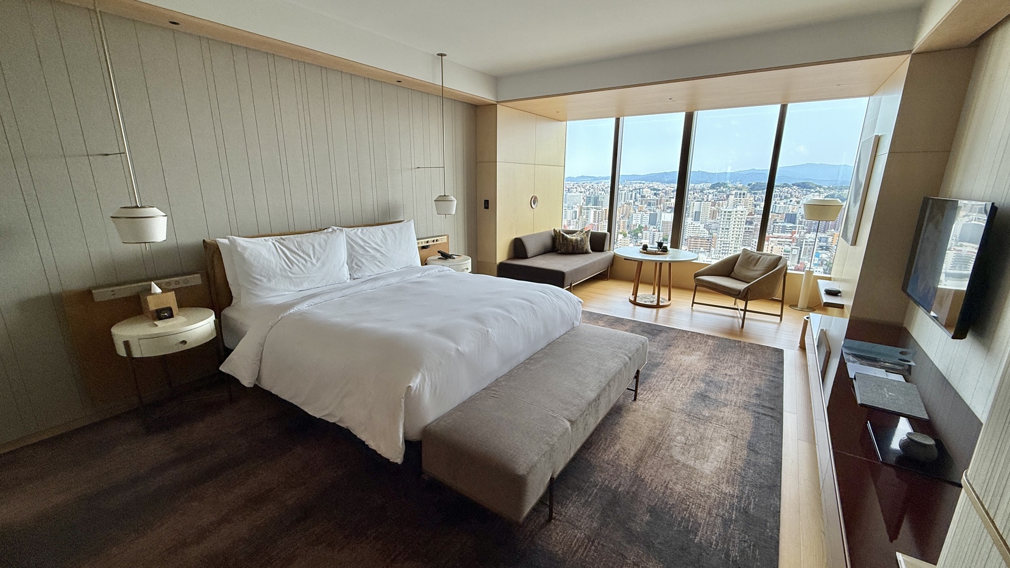 King bed with the skyline view window and seating area beyond