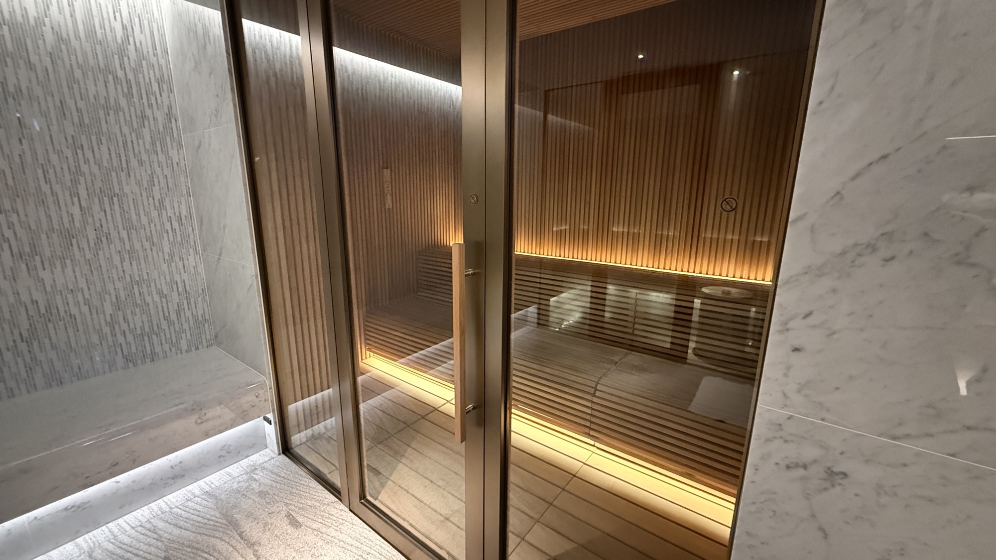 Wood lined sauna behind glass