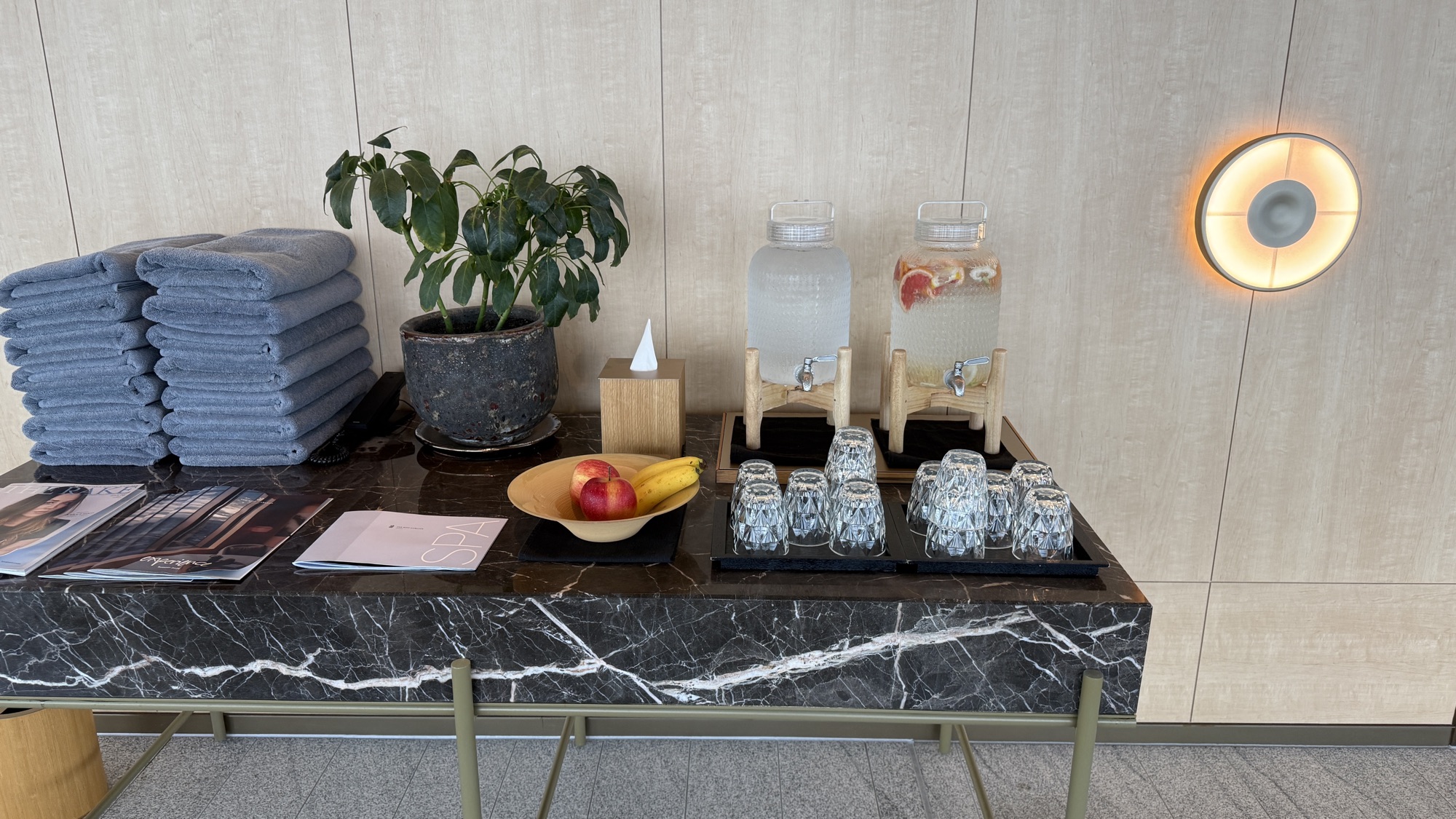 Folded towels, infused water and fresh fruit set out for guests