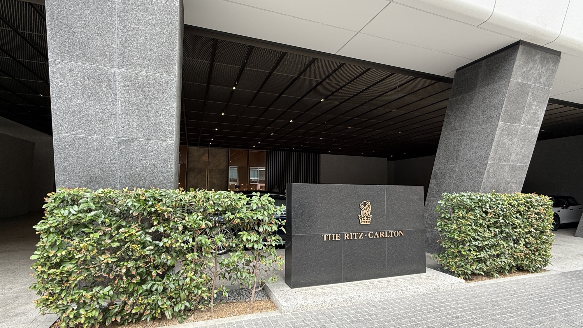 The Ritz-Carlton signage and hedging at the street entrance