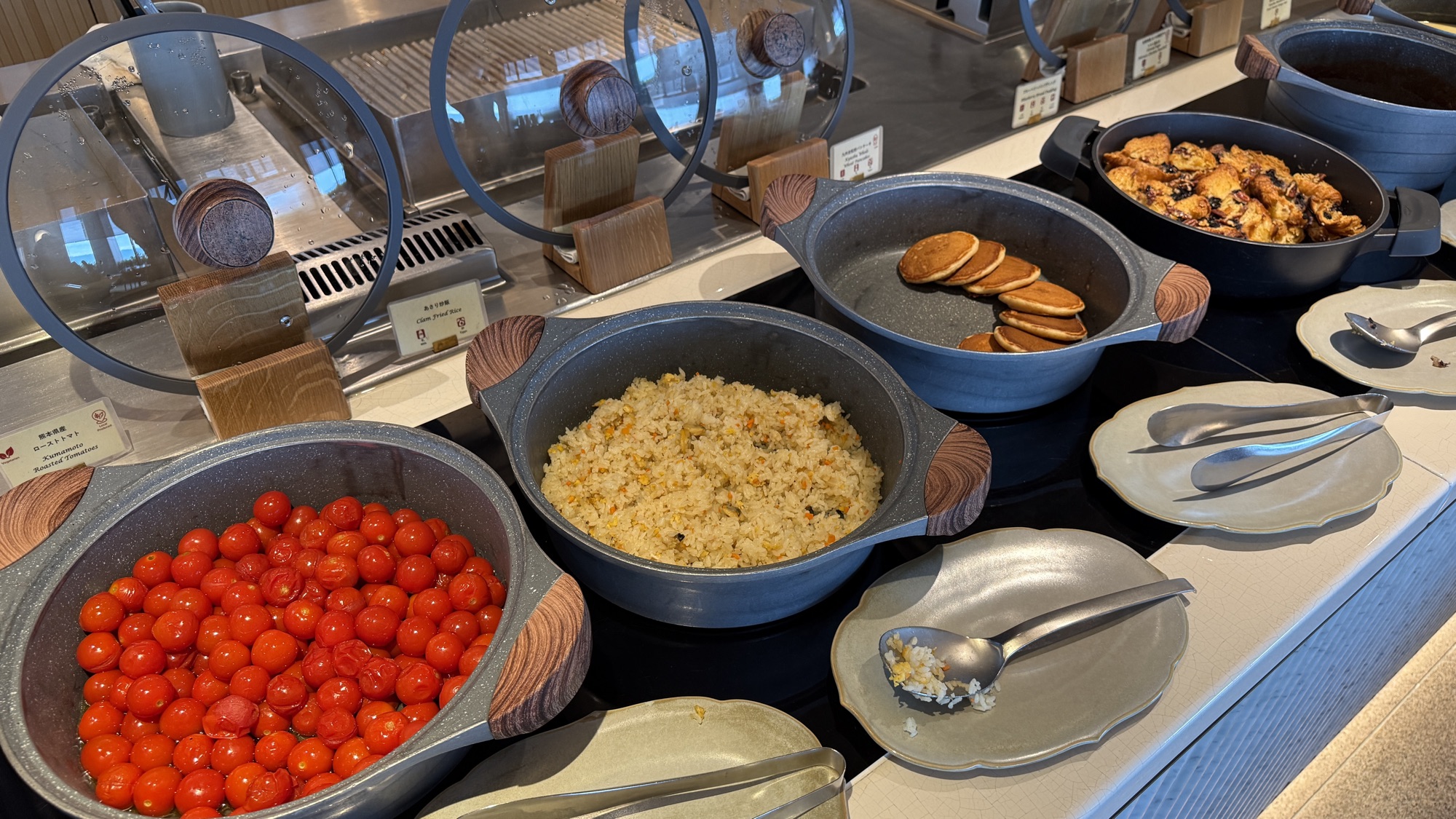 Hot buffet station with cherry tomatoes, fried rice and pancakes