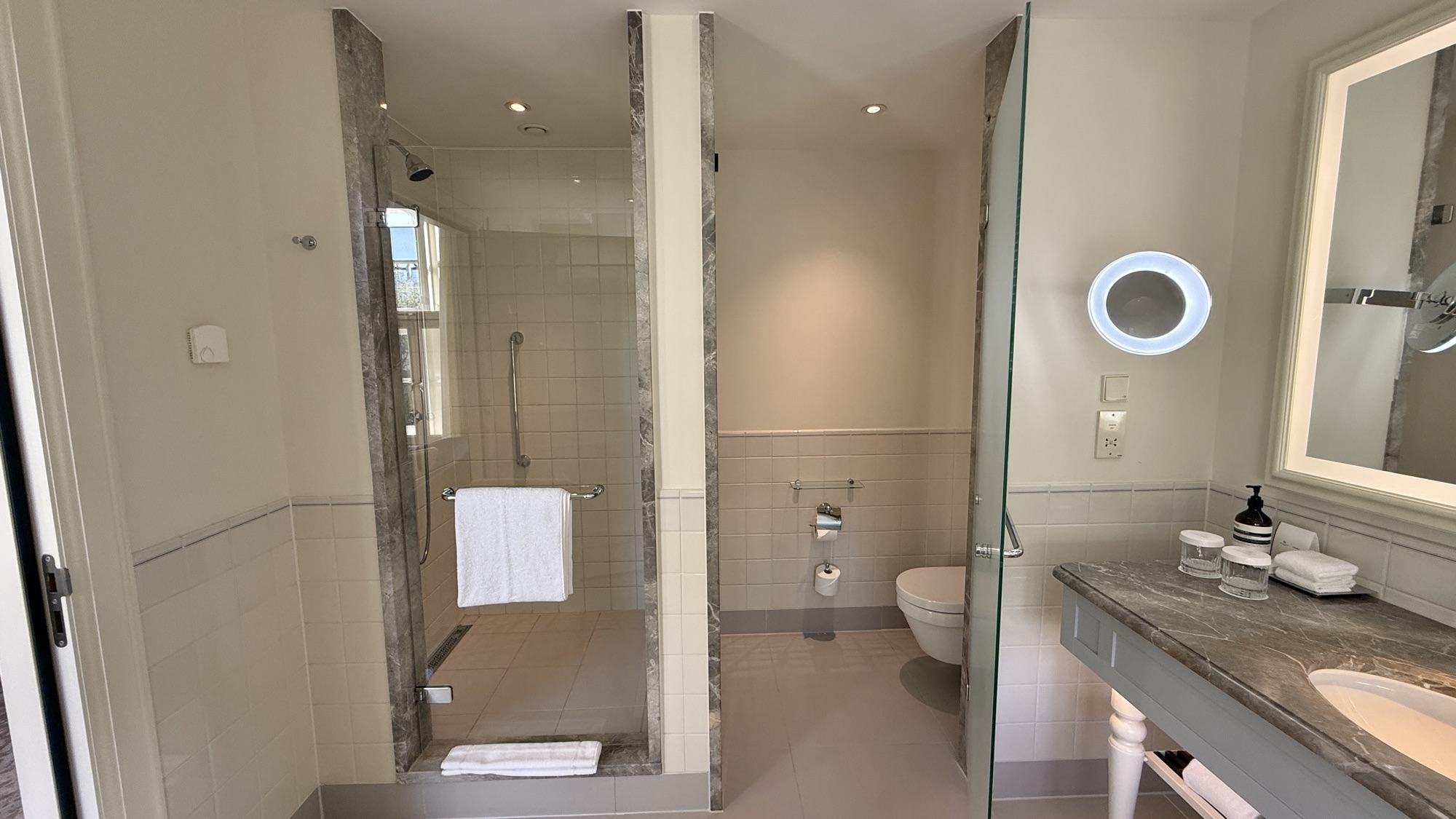 Bathroom with a walk-in rain shower, toilet, and marble finishes