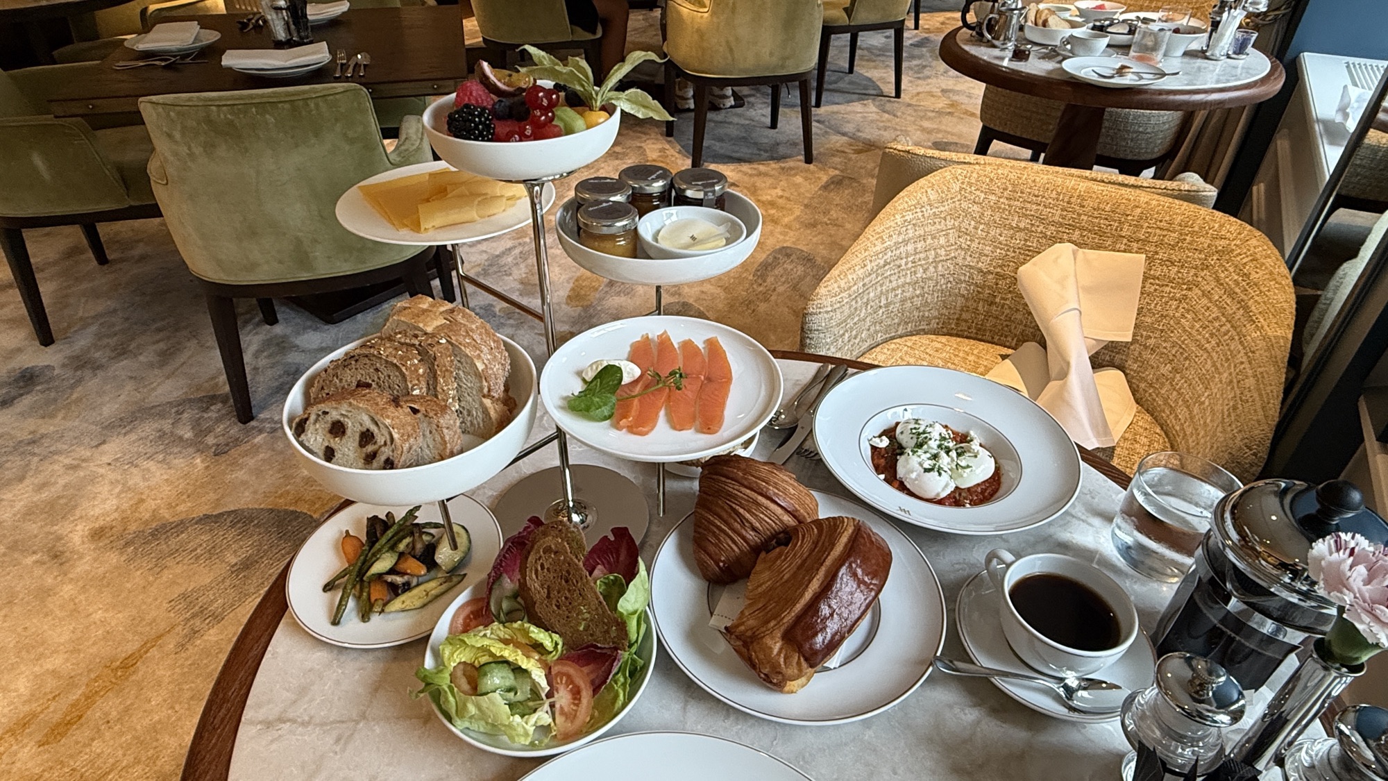 Taste of Waldorf breakfast spread with pastries, smoked salmon, cheese, salad, and coffee